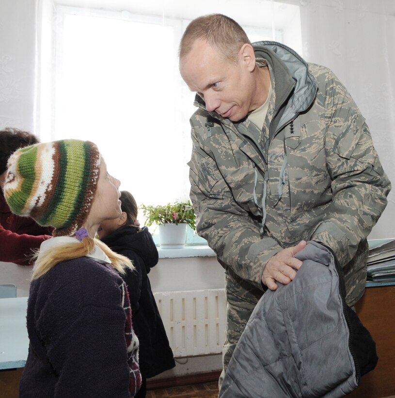 Gen. Donald J. Hoffman hands a warm coat to an elementary school girl Feb. 9, 2010, at the Grozd School in Grozd Village, Kyrgyzstan. General Hoffman is the commander of the Air Force Materiel Command. (U.S. Air Force photo/Senior Airman Nichelle Anderson)