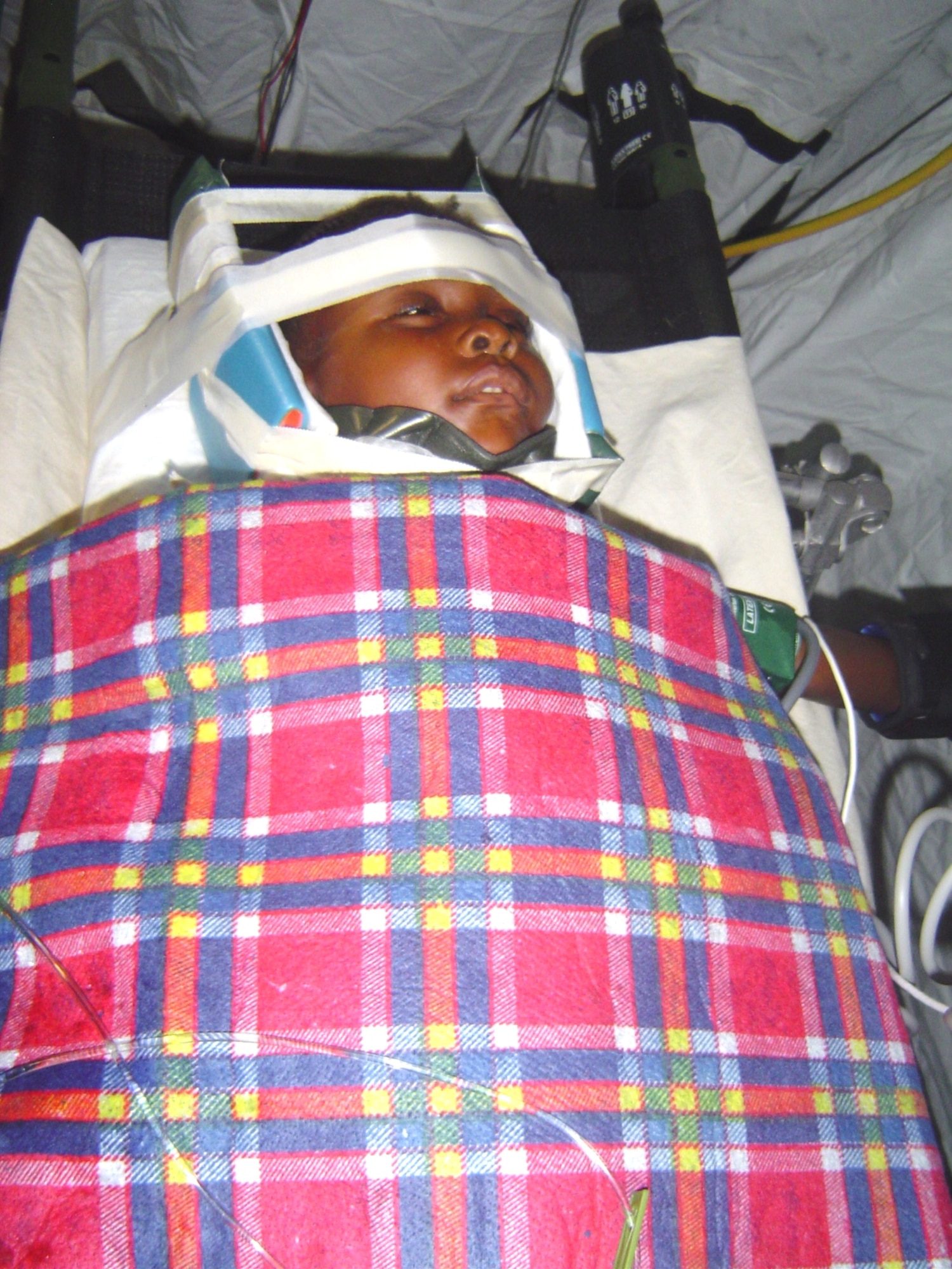 A four-year-old girl with a cervical fracture and spinal cord injury had her neck immobilized by CCATT members from Keesler AFB during a flight from Haiti to a medical facility in Florida Feb 7. Keesler CCAT teams are providing medical care to victims of the Haiti earthquake who are airlifted to hospitals in the United States. (U.S. Air Force photo/Maj. (Dr.) Stephen Boskovich)