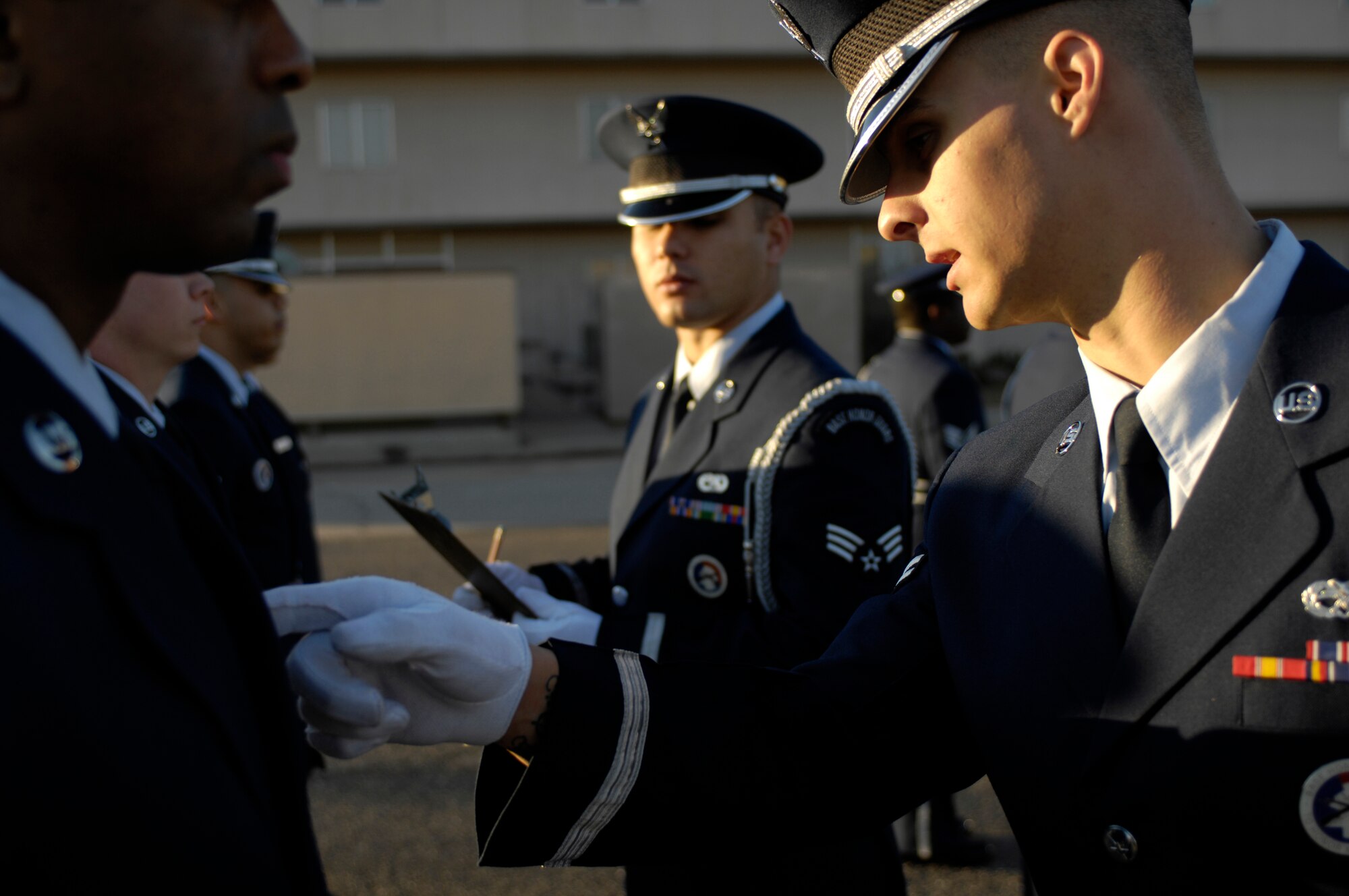 Airman 1st Class Michael Giles, Luke Honor Guard Flight Sergeant, inspects Senior Airman Mychael White while Senior Airman Kevin Borja, Flight Trainer, makes notes during an open ranks inspection on the morning of Feb. 9 at Luke Air Force Base, Ariz. The Honor Guard often represents the Air Force at local events and military funerals. (U.S. Air Force Photo by SSgt Jason Colbert)