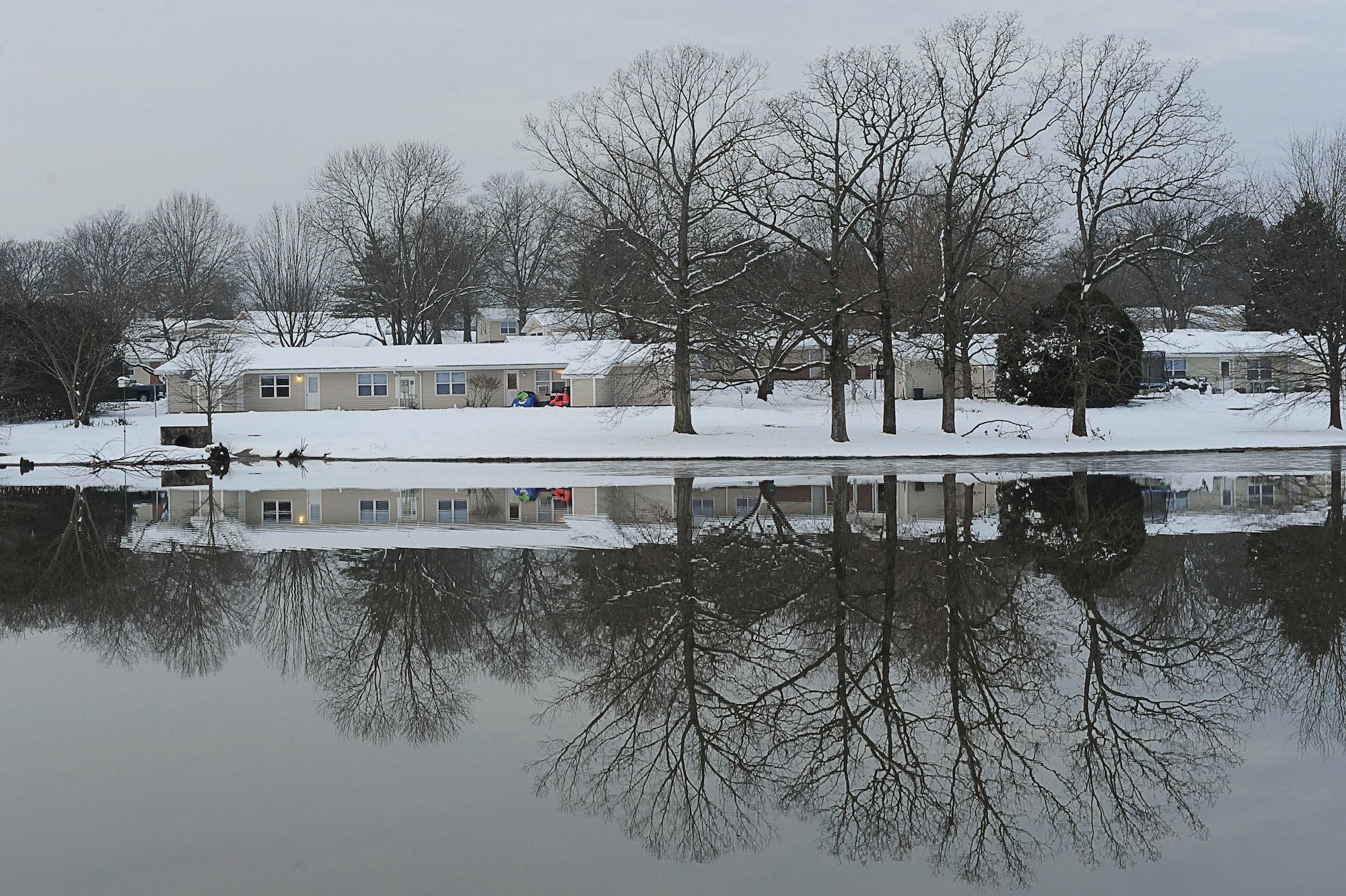Snow-covered houses and trees reflect off the big base lake in the early morning hours on Feb. 11. The base received heavy snow fall covering the entire base and creating visually striking scenery.  (U.S. Air Force photo by Staff Sgt. Chad Chisholm)