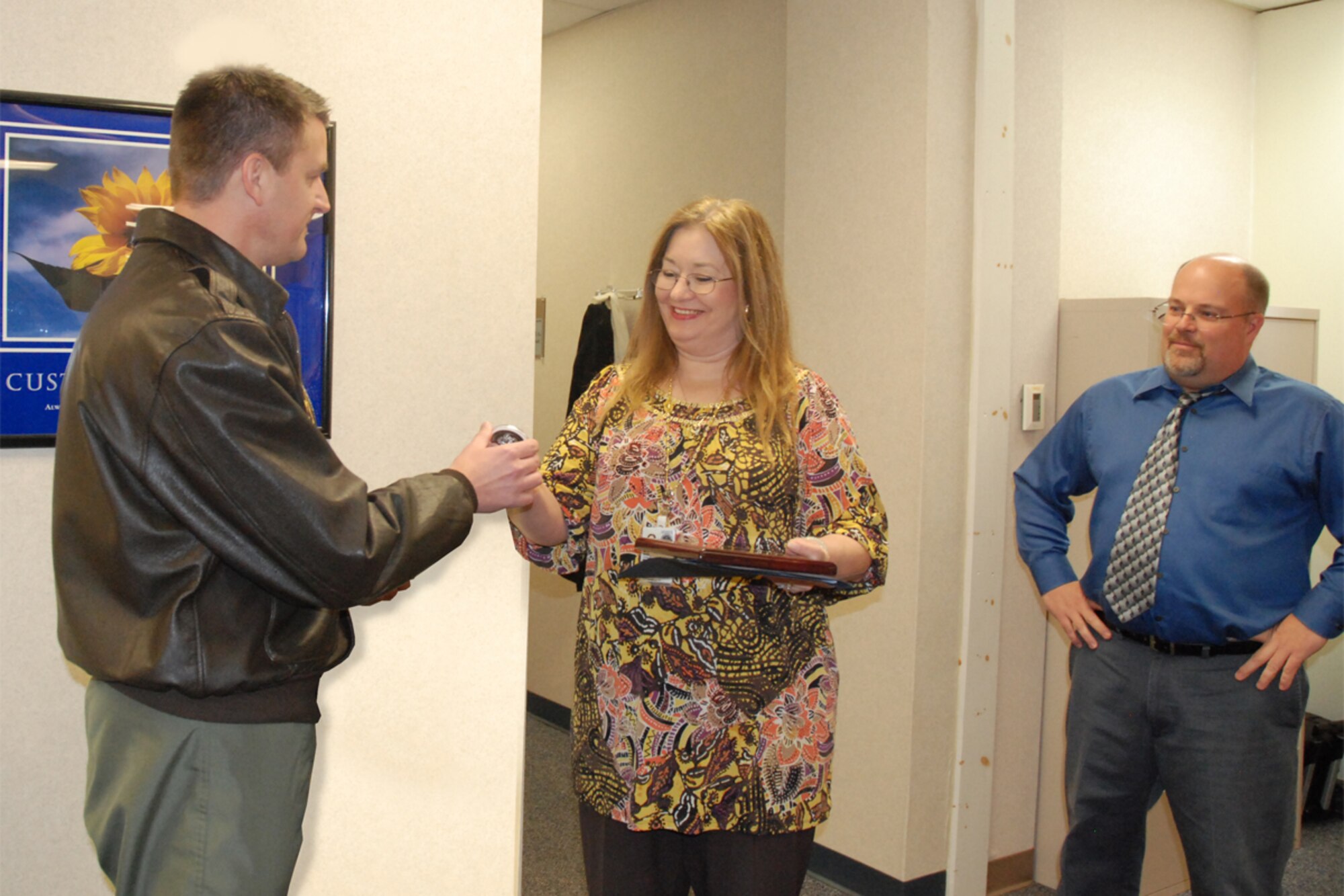 Col. Heath J. Nuckolls, commander, 94th Airlift Wing, presents the 2009 Air Force Reserve Command Financial Management Non-Acquisition Analyst of the Year Award and his Commander’s Coin to Cindy R. Ames, management analyst, 94th Financial Management as Comptroller Michael Carnahan looks on Feb.11. The award recognizes the most outstanding management analyst in AFRC and the contributions they have made to the Air Force Reserve mission. (U.S. Air Force photo/Tech. Sgt. James Branch)
