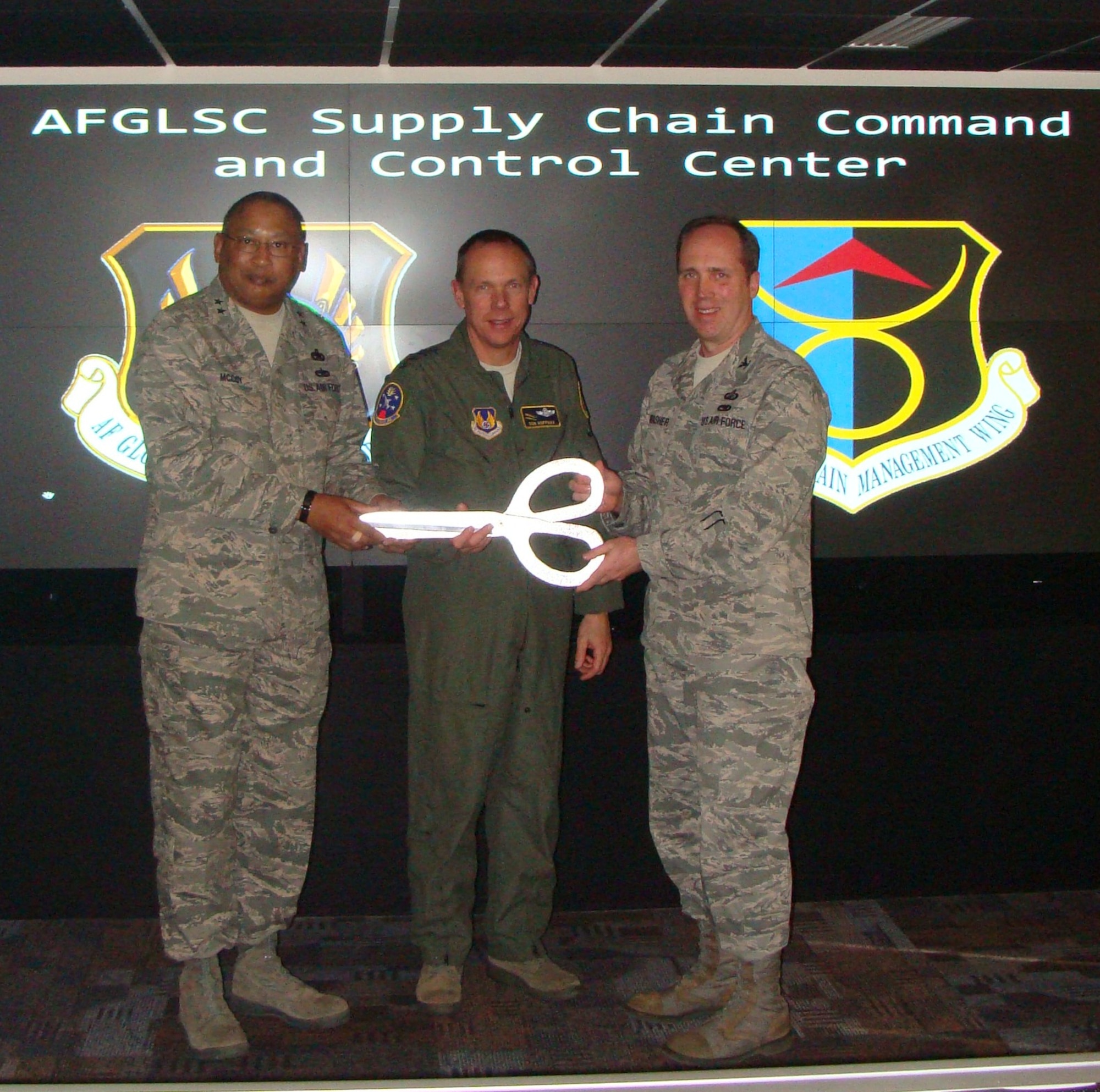 Maj. Gen. Gary McCoy, commander of the Air Force Global Logistics Support Center; Gen. Donald Hoffman, commander of Air Force Materiel Command; and Col. Roger Thrasher, commander of the 635th Supply Chain Managment Wing; pose with ceremonial scissors after cutting the ribbon for the revamped Supply Chain Control Center at AFGLSC here Jan. 28, 2010.  (U.S. Air Force photo/Tech. Sgt. Steve Haas)