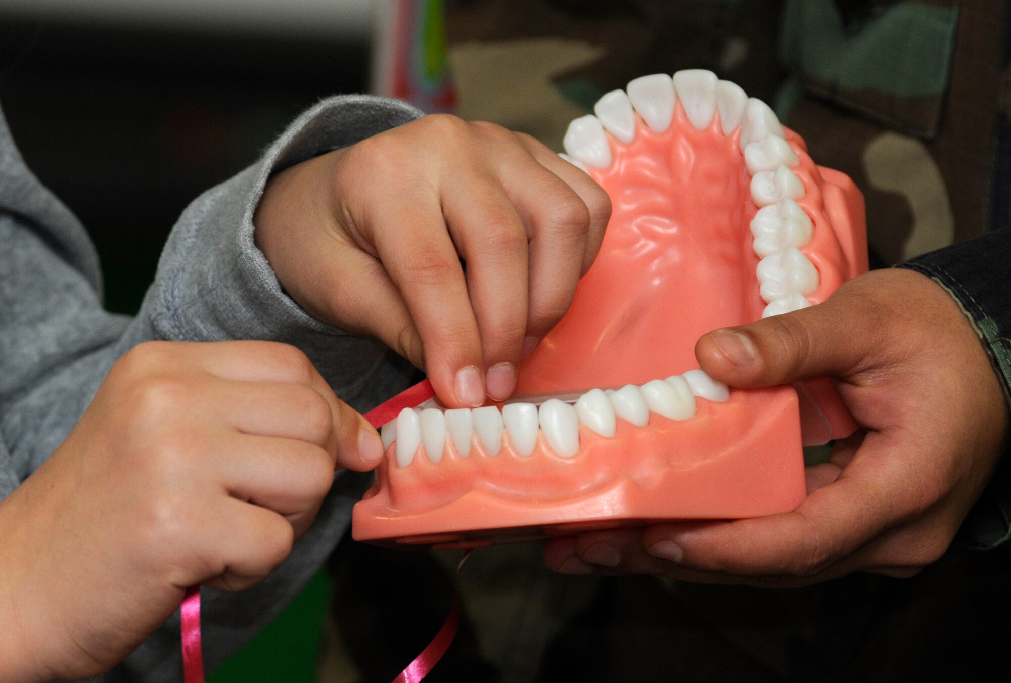 SPANGDAHLEM AIR BASE, Germany –Representatives from the 52nd Dental Squadron teach proper flossing techniques Feb. 9 at the Bitburg Elementary School. Each February, the American Dental Association sponsors National Children’s Dental Health Month. In addition to visiting elementary and middle schools, the 52nd DS is opening the Spangdahlem Dental Clinic Feb. 27 to offer walk-ins for children up to 10 years of age. (U.S. Air Force photo/Airman 1st Class Staci Miller)