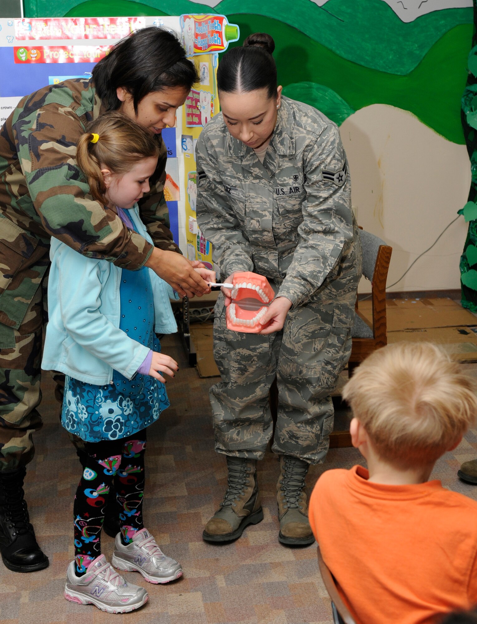 SPANGDAHLEM AIR BASE, Germany – Capt. Tonia Jhamb, left, and Airman 1st Class Ashley Ruiz, 52nd Dental Squadron, help Madelyne Comley, daughter of Tech. Sgt. Shaun Comley, 52nd Component Maintenance Squadron, show her first grade classmates the proper way to brush their teeth Feb. 9 at the Bitburg Elementary School. Each February, the American Dental Association sponsors National Children’s Dental Health Month. In addition to visiting elementary and middle schools, the 52nd DS is opening the Spangdahlem Dental Clinic Feb. 27 to offer walk-ins for children up to 10 years of age. (U.S. Air Force photo/Airman 1st Class Staci Miller)