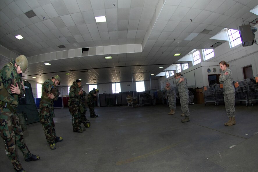 Instructors from the 22nd Civil Engineer Squadron emergency management flight, demonstrate a mission-oriented protective posture dance with students, Jan. 26, 2010, during a survival skills training class at McConnell Air Force Base, Kan.  The “MOPP dance” is a morale-boosting method to reinforce what level of protection clothing must be worn during the various stages of MOPP. (U.S. Air Force photo/Staff Sgt. Anthony Mejia)