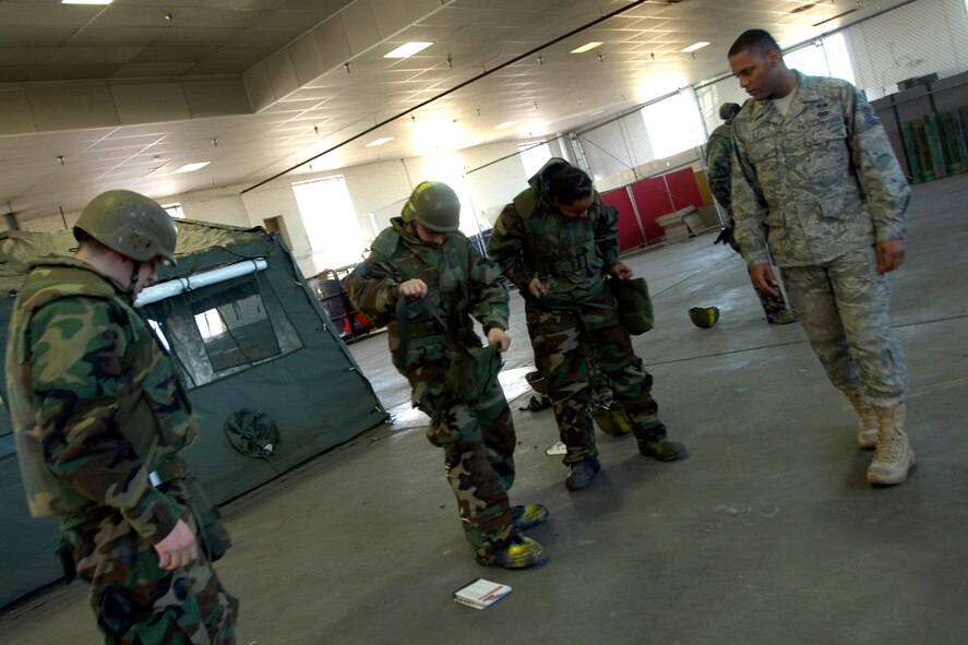 Tech. Sgt. Thomas Cyphers, 22nd Civil Engineer Squadron emergency management training NCOIC, observes as students don their mission-oriented protective posture gear, Jan. 25, 2010, during a survival skills training class at McConnell Air Force Base, Kan.  EM instructors train about 120 McConnell Airmen each month. (U.S. Air Force photo/Staff Sgt. Anthony Mejia)