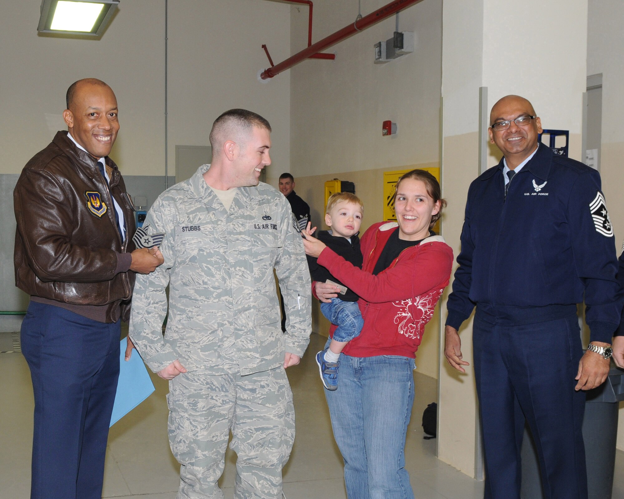 Brig. Gen. C.Q. Brown Jr., 31st Fighter Wing commander shows the STEP promotion stripe of Tech. Sgt. Adam Stubbs, 31st Munitions Squadron, along with his wife Kelly, their son Ashton, and Chief Master Sergeant Laten Williams, 31st FW command chief. Tech. Sgt. Stubbs was awarded the new stripe through the Stripes for Exceptional Performers program. (U.S. Air Force photo/Staff Sgt. MercedesKimble L. Crossland)  