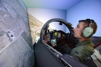 First Lt. Dustin Duke, training with the 560th Flying Training Squadron at Randolph Air Force Base, TX, to be a T-38 instructor pilot at Whiteman Air Force Base, MO, checks for clearance while in a left turn during an emergency procedures simulator flight. (U.S. Air Force photo/Steve Thurow)