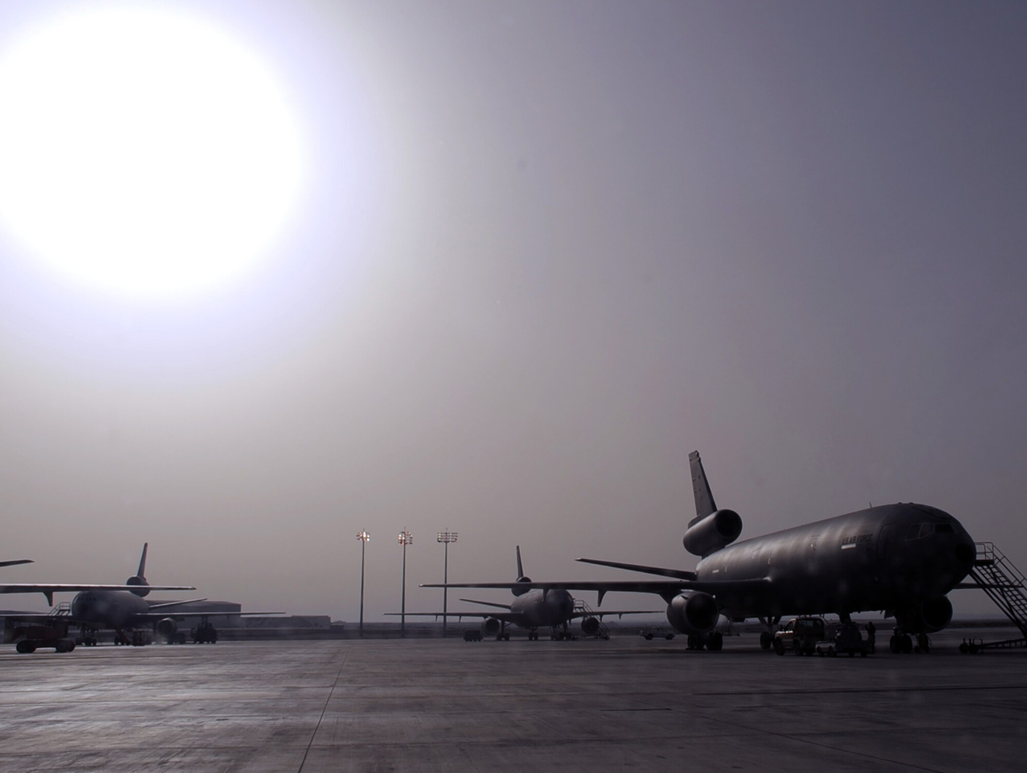 The sun silouettes parked KC-10 Extenders on the flightline at a non-disclosed base in Southwest Asia on Feb. 11, 2010.  The KC-10 Extenders are a part of the 908th Expeditionary Air Refueling Squadron of the 380th Air Expeditionary Wing. KC-10s assigned to the 908th EARS fly combat air refueling missions in support of Operations Enduring Freedom, the Combined Joint Task Force-Horn of Africa and Operation Iraqi Freedom. The KC-10 is the Air Force's largest tanker and in 2009, aircraft assigned to the 908th EARS flew more than 4,700 combat missions offloading more than 422 million pounds of fuel to more than 31,400 aircraft.  (U.S. Air Force Photo/Master Sgt. Scott T. Sturkol/Released)