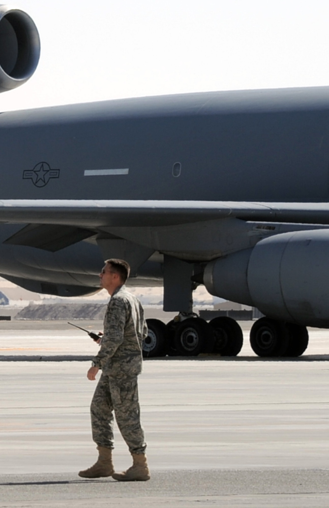 Maj. Brian Hood, deployed with the 908th Expeditionary Air Refueling Squadron, checks on flightline operations as he walks past a KC-10 Extender at a non-disclosed base in Southwest Asia in Feb. 10, 2010.  Major Hood is deployed from 32nd Air Refueling Squadron at Joint Base McGuire-Dix-Lakehurst, N.J., and the KC-10 is from Travis Air Force Base, Calif. The 908th EARS is a part of the 380th Air Expeditionary Wing and the KC-10s assigned to the wing fly combat air refueling missions in support of Operations Enduring Freedom, the Combined Joint Task Force-Horn of Africa and Operation Iraqi Freedom. The KC-10 is the Air Force's largest tanker and in 2009, aircraft assigned to the 908th EARS flew more than 4,700 combat missions offloading more than 422 million pounds of fuel to more than 31,400 aircraft.  (U.S. Air Force Photo/Master Sgt. Scott T. Sturkol/Released)