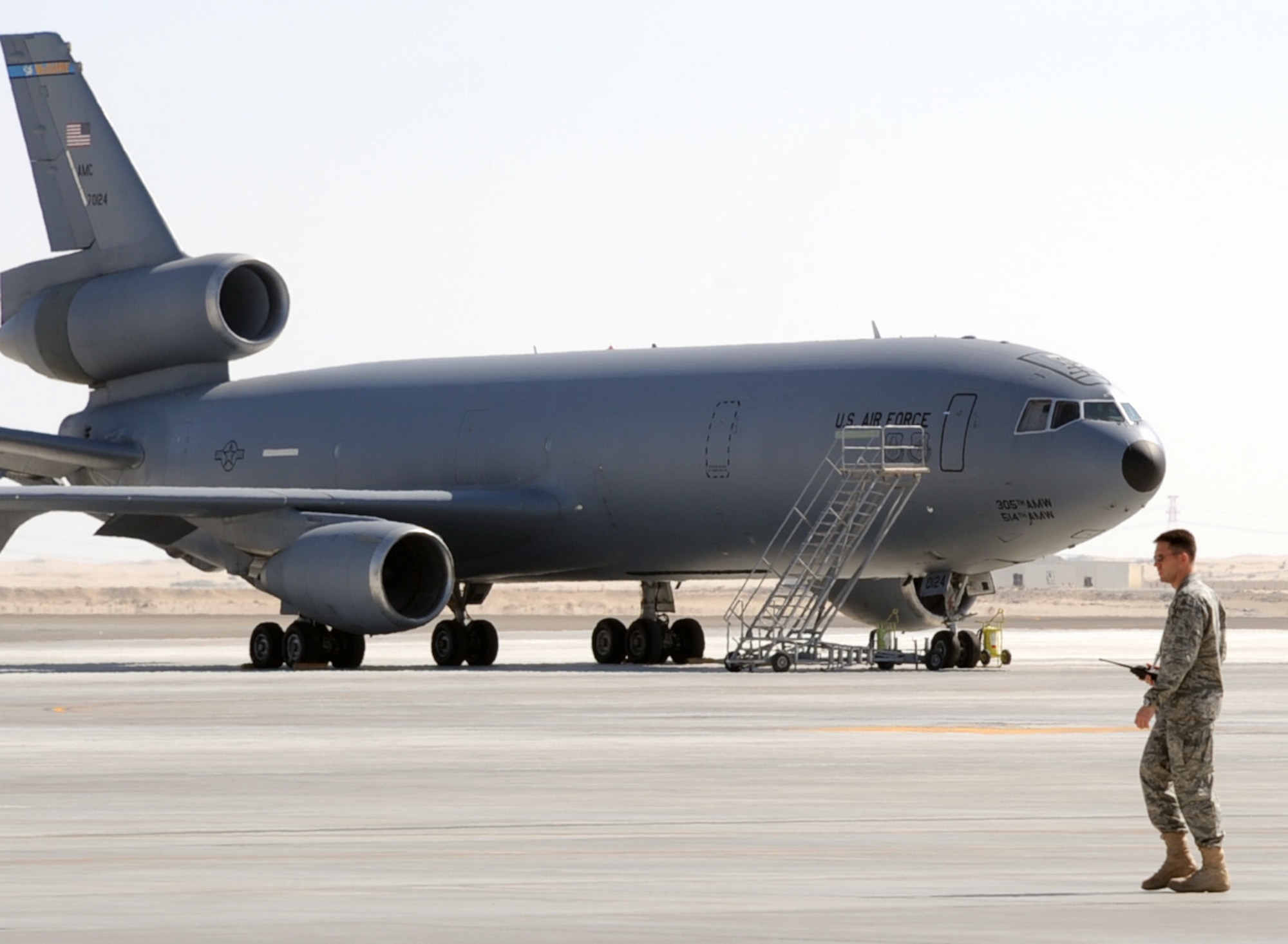 Maj. Brian Hood, deployed with the 908th Expeditionary Air Refueling Squadron, checks on flightline operations as he walks past a KC-10 Extender at a non-disclosed base in Southwest Asia in Feb. 10, 2010.  Major Hood is deployed from 32nd Air Refueling Squadron at Joint Base McGuire-Dix-Lakehurst, N.J., and the KC-10 is from Travis Air Force Base, Calif. The 908th EARS is a part of the 380th Air Expeditionary Wing and the KC-10s assigned to the wing fly combat air refueling missions in support of Operations Enduring Freedom, the Combined Joint Task Force-Horn of Africa and Operation Iraqi Freedom. The KC-10 is the Air Force's largest tanker and in 2009, aircraft assigned to the 908th EARS flew more than 4,700 combat missions offloading more than 422 million pounds of fuel to more than 31,400 aircraft.  (U.S. Air Force Photo/Master Sgt. Scott T. Sturkol/Released)
