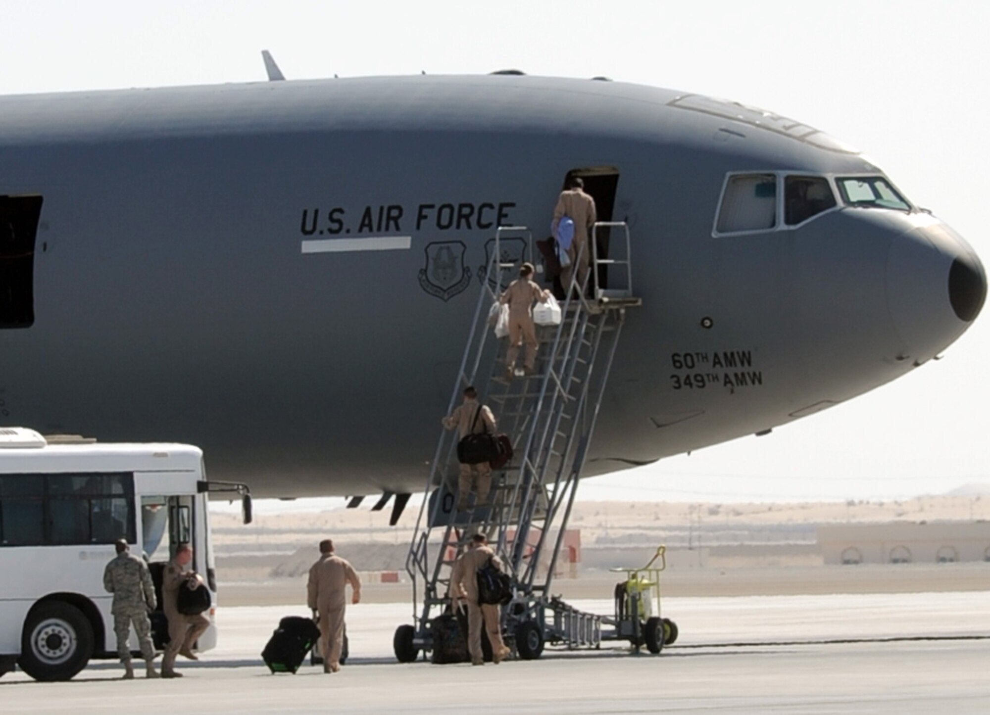 Flight crew members carry gear up the air stairs into a KC-10 Extender prior to departure on a mission at a non-disclosed base in Southwest Asia on Feb. 10, 2010.  The KC-10 Extender, deployed from Travis Air Force Base, Calif., is a part of the 908th Expeditionary Air Refueling Squadron of the 380th Air Expeditionary Wing. KC-10s assigned to the 908th EARS fly combat air refueling missions in support of Operations Enduring Freedom, the Combined Joint Task Force-Horn of Africa and Operation Iraqi Freedom. The KC-10 is the Air Force's largest tanker and in 2009, aircraft assigned to the 908th EARS flew more than 4,700 combat missions offloading more than 422 million pounds of fuel to more than 31,400 aircraft.  (U.S. Air Force Photo/Master Sgt. Scott T. Sturkol/Released)