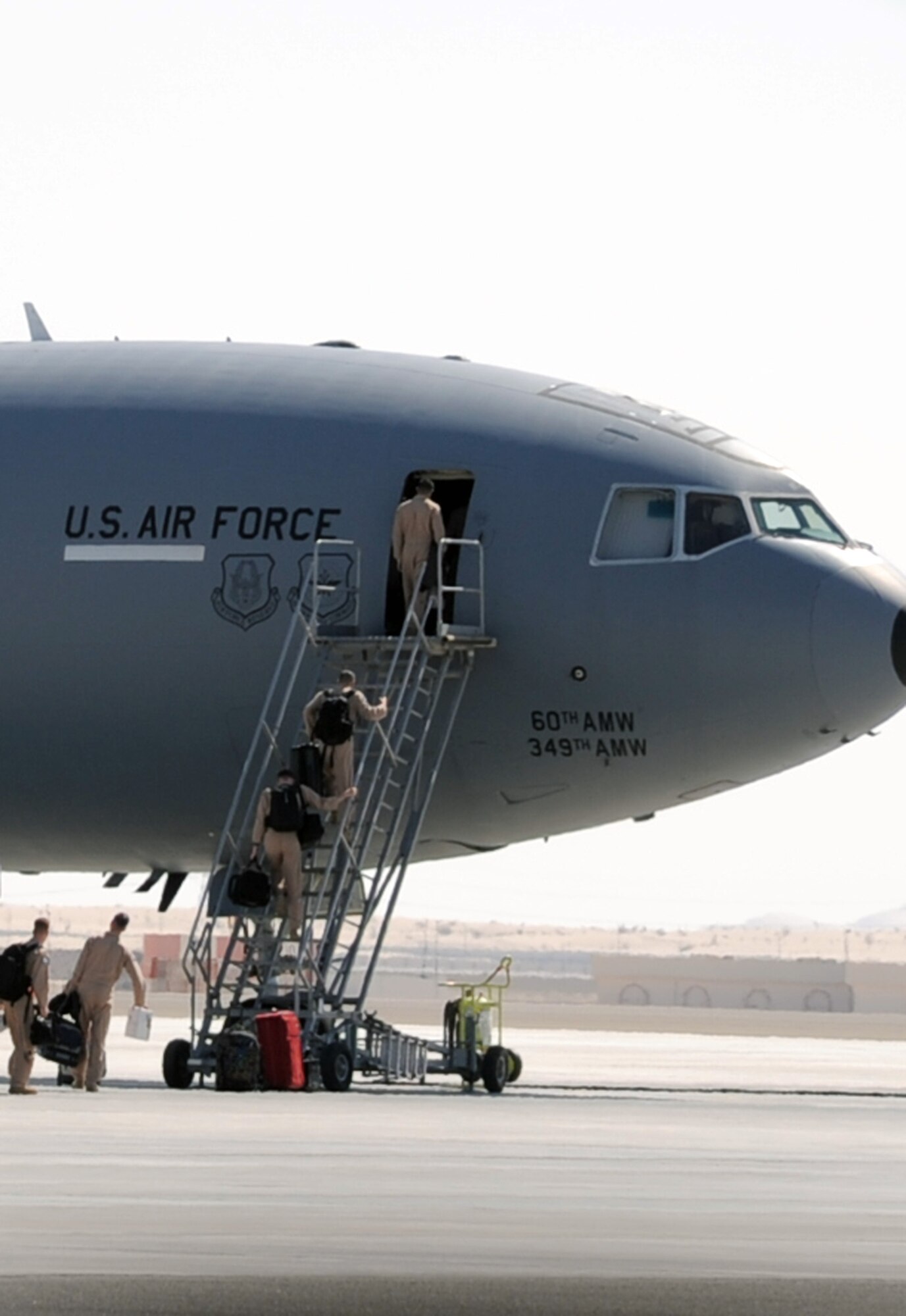 Flight crew members carry gear up the air stairs in to a KC-10 Extender prior to departure on a mission at a non-disclosed base in Southwest Asia in Feb. 10, 2010.  The KC-10 Extender, deployed from Travis Air Force Base, Calif., is a part of the 908th Expeditionary Air Refueling Squadron of the 380th Air Expeditionary Wing. KC-10s assigned to the 908th EARS fly combat air refueling missions in support of Operations Enduring Freedom, the Combined Joint Task Force-Horn of Africa and Operation Iraqi Freedom. The KC-10 is the Air Force's largest tanker and in 2009, aircraft assigned to the 908th EARS flew more than 4,700 combat missions offloading more than 422 million pounds of fuel to more than 31,400 aircraft.  (U.S. Air Force Photo/Master Sgt. Scott T. Sturkol/Released)