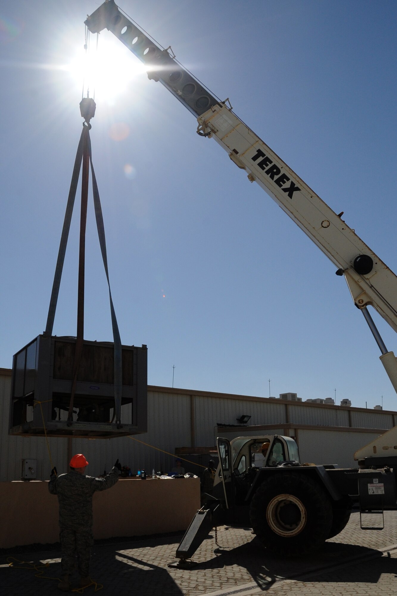 Members of the 380th Expeditionary Civil Engineer Squadron remove an air conditioning unit from the dining facility at an undisclosed location in Southwest Asia on Feb. 10, 2010.  A new unit was installed to increase the cooling efficiency for the building before summer temperatures rose. (U.S. Air Force photo/Senior Airman Jenifer H. Calhoun/Released)
