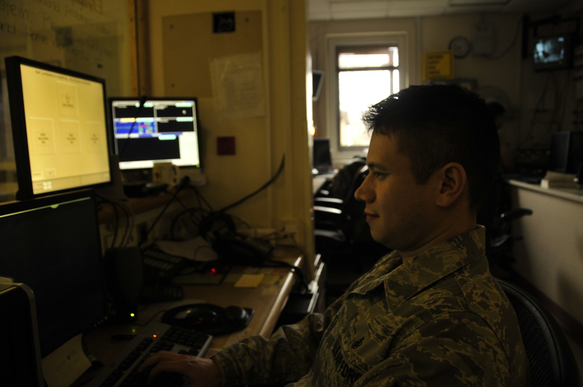 Tech. Sgt. Rodney Embree, 48th Medical Operations Squadron emergency room technician, mans the patient check-in desk in the emergency room at RAF Lakenheath, England. The lights are kept low to avoid off-setting the one-way mirror used to protect patient privacy. (U.S. Air Force photo/Airman 1st Class Eboni Knox)