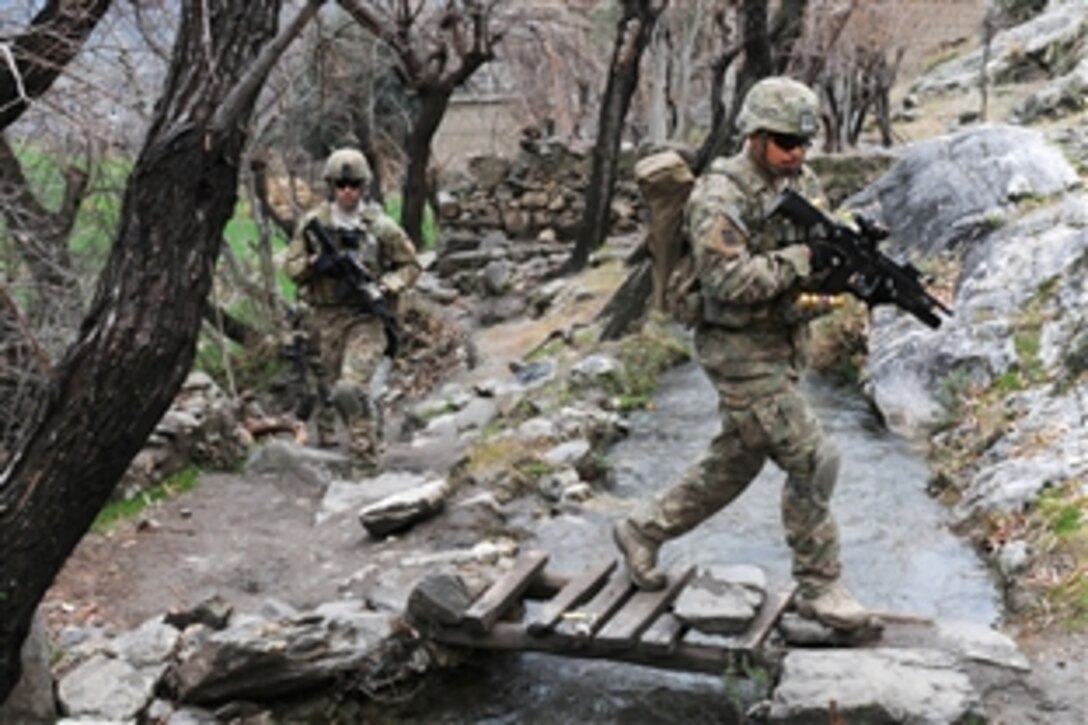 U.S. Army Spc. Jesus B. Fernandez crosses a stream during a unit visit to Angla Kala village in Afghanistan's Kunar province, Feb. 6, 2010. International Security Assistance Force troops regularly meet with village elders to improve communications between residents and government officials. Fernandez is an assistant team leader assigned to the 2nd Battalion, 12th Infantry Regiment, 4th Brigade Combat Team.