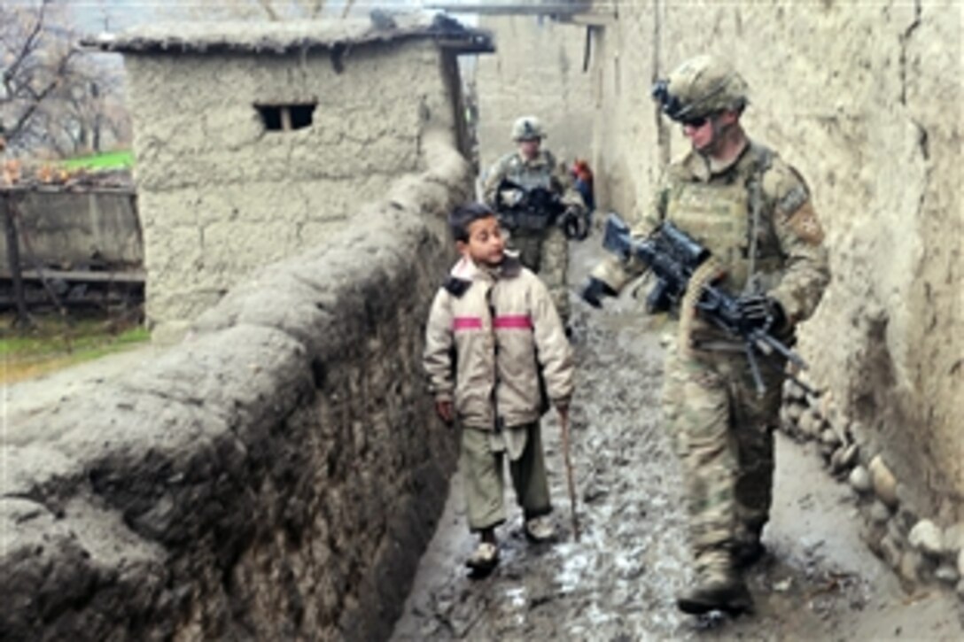 U.S. Army Pfc. John D. Macintosh talks with a boy from the Wata Poor district while on patrol in Afghanistan's Kunar province, Feb. 7, 2010. Macintosh is a gunner with the 12th Infantry Regiment, 4th Brigade Combat Team.