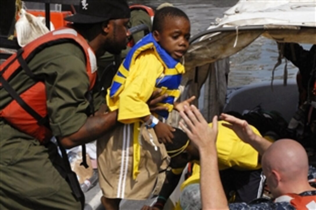 U.S. Navy sailors assigned to the USNS Comfort and Haitian citizens disembark patients released from the Comfort to an intermediate aftercare facility in Killic, Haiti, Feb. 5, 2010. The Comfort is conducting humanitarian and disaster relief operations as part of Operation Unified Response after an earthquake devastated the island nation.