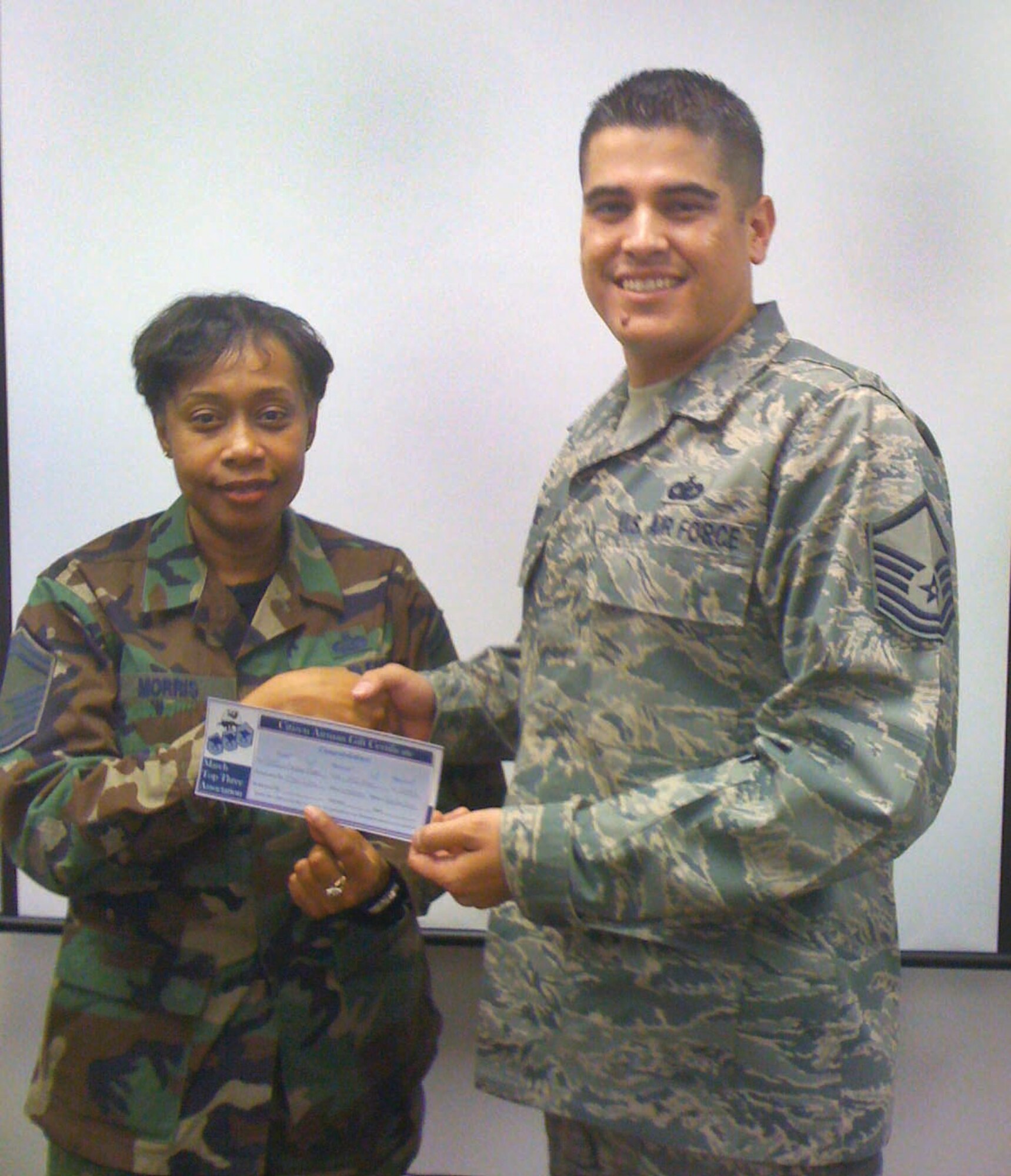Master Sgt. Octavio Ortiz (right) recently awarded the Top Three’s first Citizen Airman Gift Certificate to Senior Master Sgt. Barbara Morris, 452 MSG. Sergeant Morris led the March Field toy drive for the 2009 Marine Toys for Tots Foundation. Her efforts contributed to the collection of over 250 toys, ensuring the Marine Corps met the significant challenge of providing holiday joy and cheer to many. (U.S. Air Force  photo)  