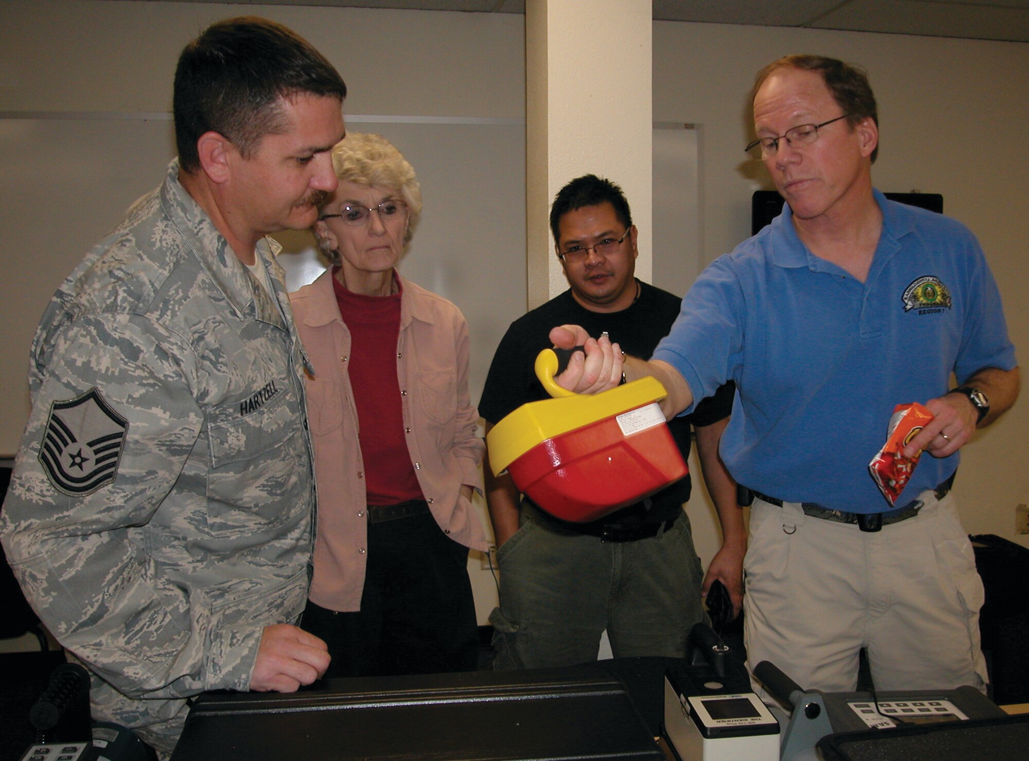(from left) Master Sgt. Phillip Hartzell, Nancy Driscoll, Edward Crisostomo and Joel Swanson discuss a radiological detection device during a break in the presentation Swanson recently was giving on base. Swanson is a contractor response coordinator for the U.S. Department of Energy’s Region 7, which includes all of California. March ARB first and emergency responders attended the session, which promoted interagency cooperation. (U.S. Air Force photo by Megan Just)