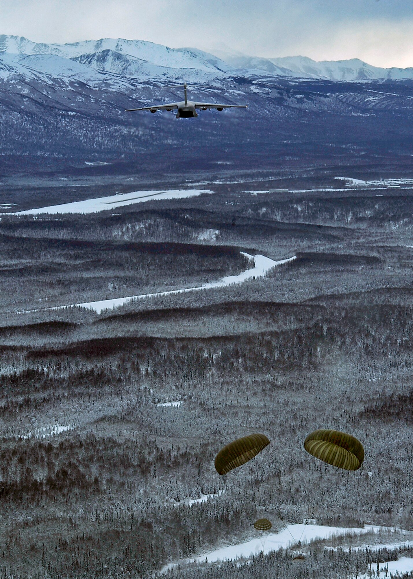 ELMENDORF AIR FORCE BASE, Alaska -- A C-17 Globemaster IIIs from the 517th Airlift Squadron drops its cargo over the drop zone near Katchemak bay, Alaska Feb. 10. The aircraft were participating in an exercise that involved Pacific Air Force and Air Mobility Command C-17s exploring capabilities in large formations and improving tactical awareness among aircrews. (Air Force photo by Senior Airman Matt Coleman-Foster)