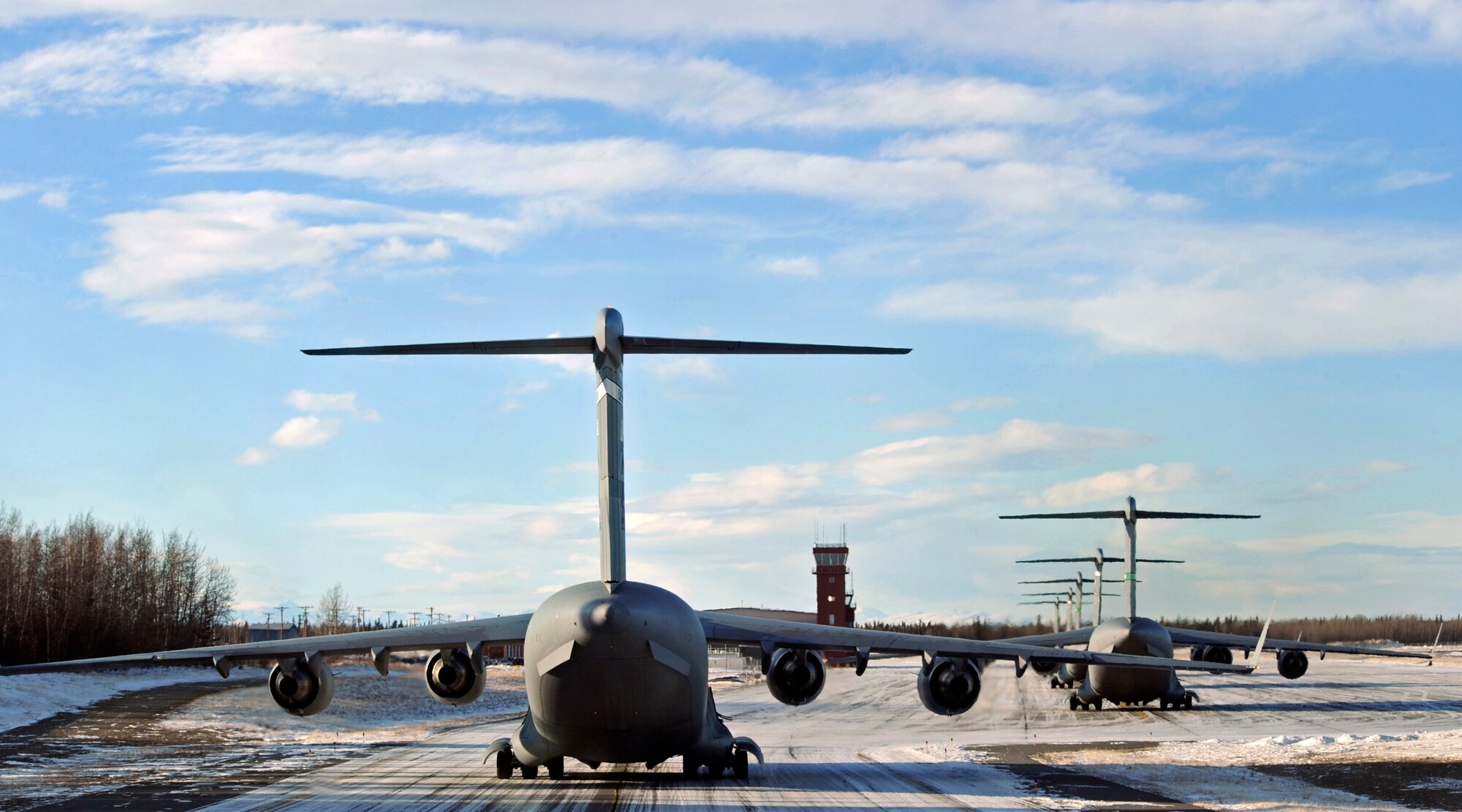 ELMENDORF AIR FORCE BASE, Alaska -- C-17 Globemaster IIIs from the Pacific Air Forces and Air Mobility Command sit on the ramp waiting to take off at Allen Army airfield in Fort Greely, Alaska Feb. 10. The aircraft were participating in an exercise that involved PACAF and AMC C-17s exploring capabilities in large formations and improving tactical awareness among aircrews.(Air Force photo by Senior Airman Matt Coleman-Foster)