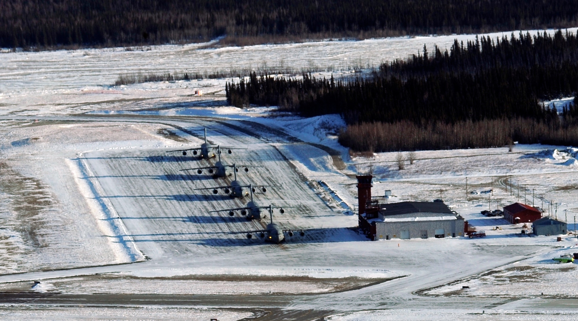 ELMENDORF AIR FORCE BASE, Alaska -- C-17 Globemaster IIIs from the Pacific Air Forces and Air Mobility Command sit on the ramp waiting to take off at Allen Army airfield in Fort Greely, Alaska Feb. 10. The aircraft were participating in an exercise that involved PACAF and AMC C-17s exploring capabilities in large formations and improving tactical awareness among aircrews. (Air Force photo by Senior Airman Matt Coleman-Foster)