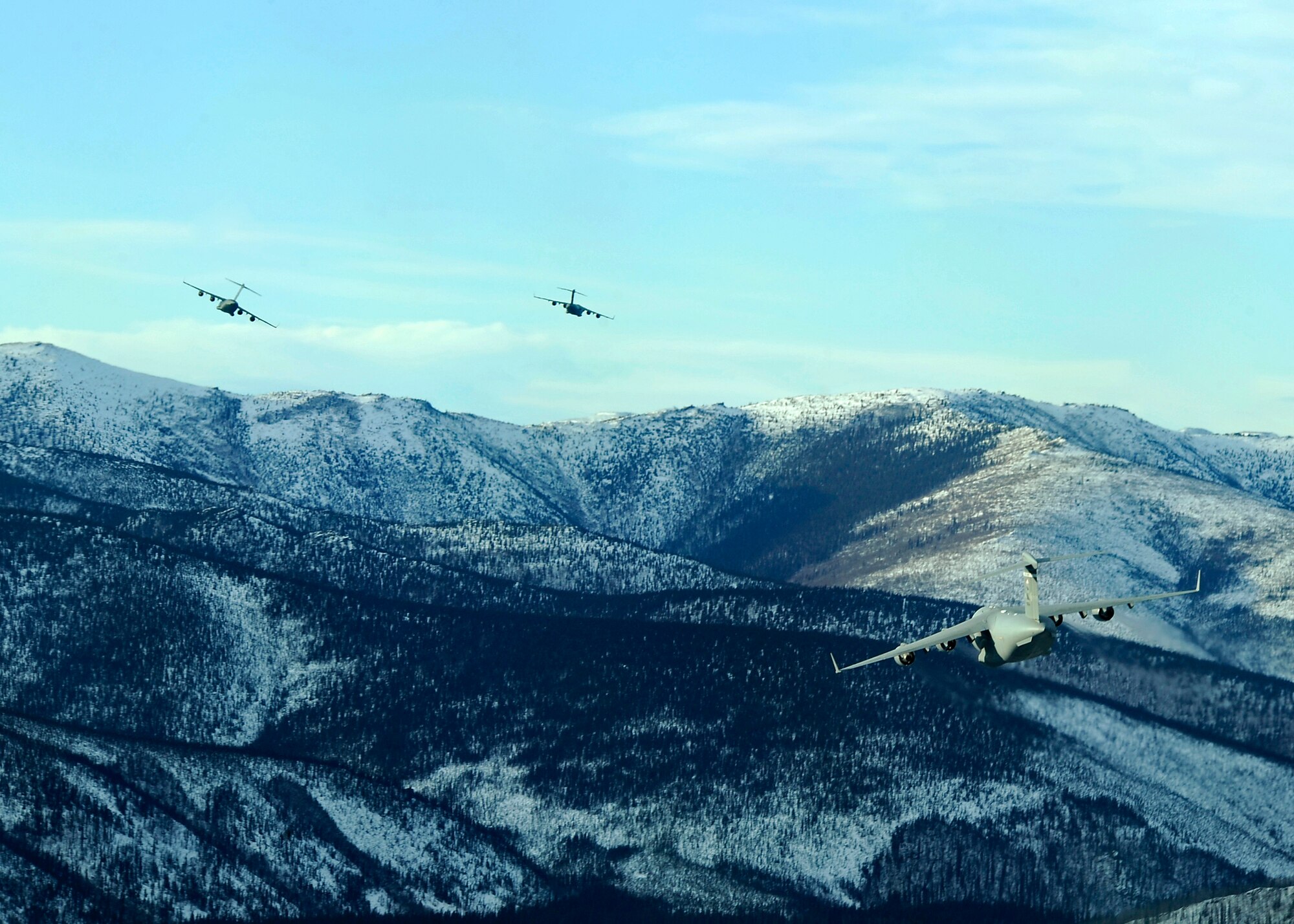 ELMENDORF AIR FORCE BASE, Alaska -- C-17 Globemaster IIIs from the Pacific Air Forces and Air Mobility Command soar over Alaskan mountain ranges near Fort Greely, Alaska Feb. 10. The aircraft were participating in an exercise that involved PACAF and AMC C-17s exploring capabilities in large formations and improving tactical awareness among aircrews. (Air Force photo by Senior Airman Matt Coleman-Foster)