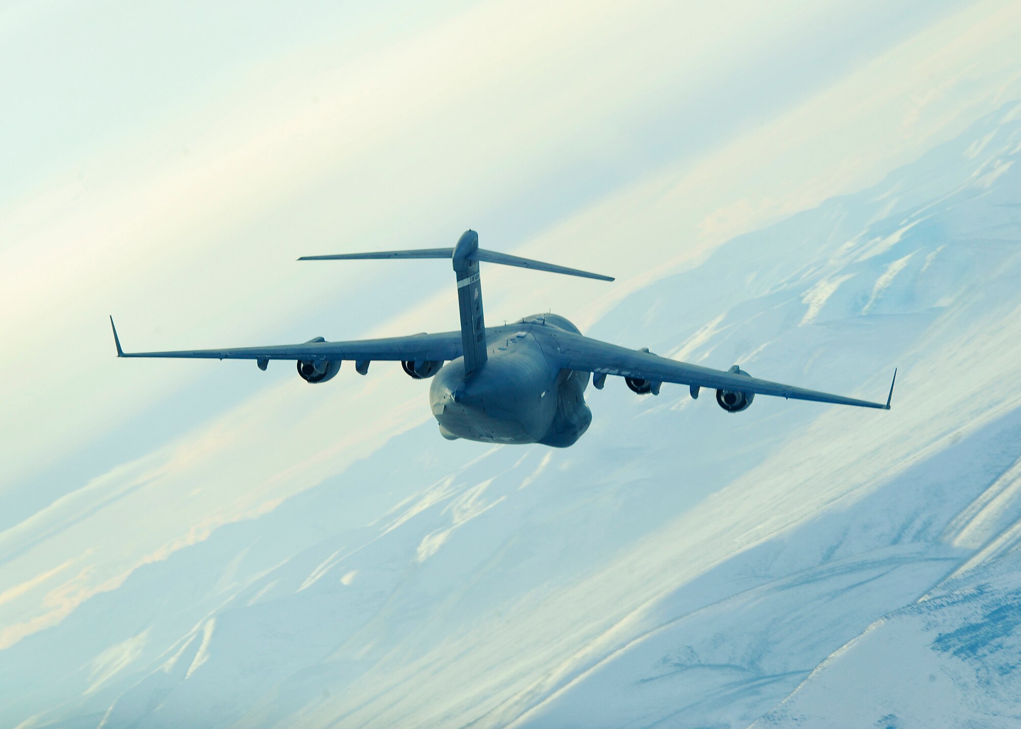 ELMENDORF AIR FORCE BASE, Alaska -- C-17 Globemaster III from the 517th Airlift Squadron soars over the mountainous landscape near Fort Greely, Alaska Feb. 10. The aircraft was participating in an exercise that involved Pacific Air Force and Air Mobility Command C-17s exploring capabilities in large formations and improving tactical awareness among aircrews. (Air Force photo by Senior Airman Matt Coleman-Foster)