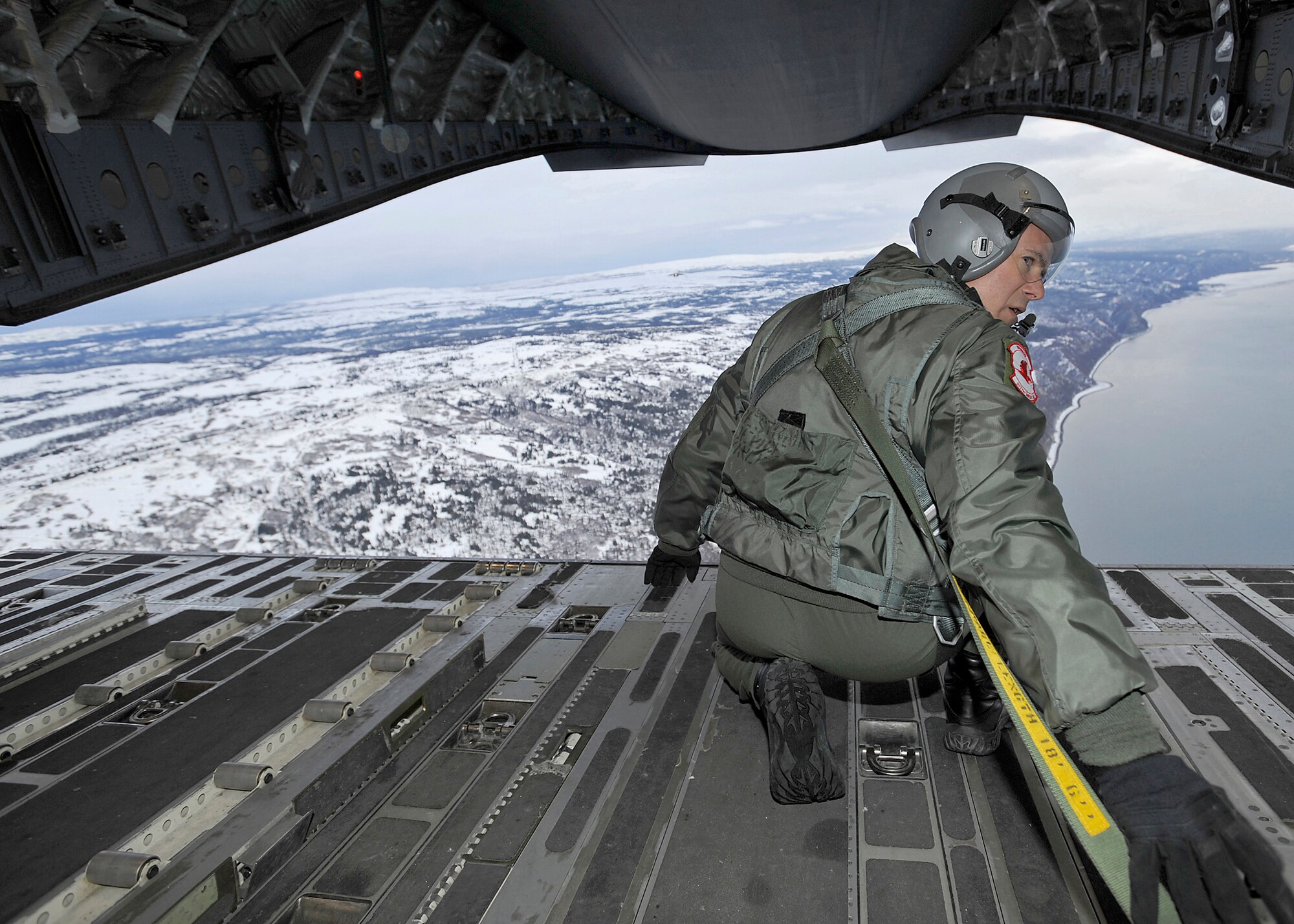 ELMENDORF AIR FORCE BASE, Alaska -- Senior Master Sgt. John Gallo, 517th Airlift Squadron, checks his location before dropping cargo over the drop zone near Katchemak bay, Alaska Feb. 10. Gallo was participating in an exercise that involved Pacific Air Force and Air Mobility Command C-17s exploring capabilities in large formations and improving tactical awareness among aircrews. (Air Force photo by Senior Airman Matt Coleman-Foster)
