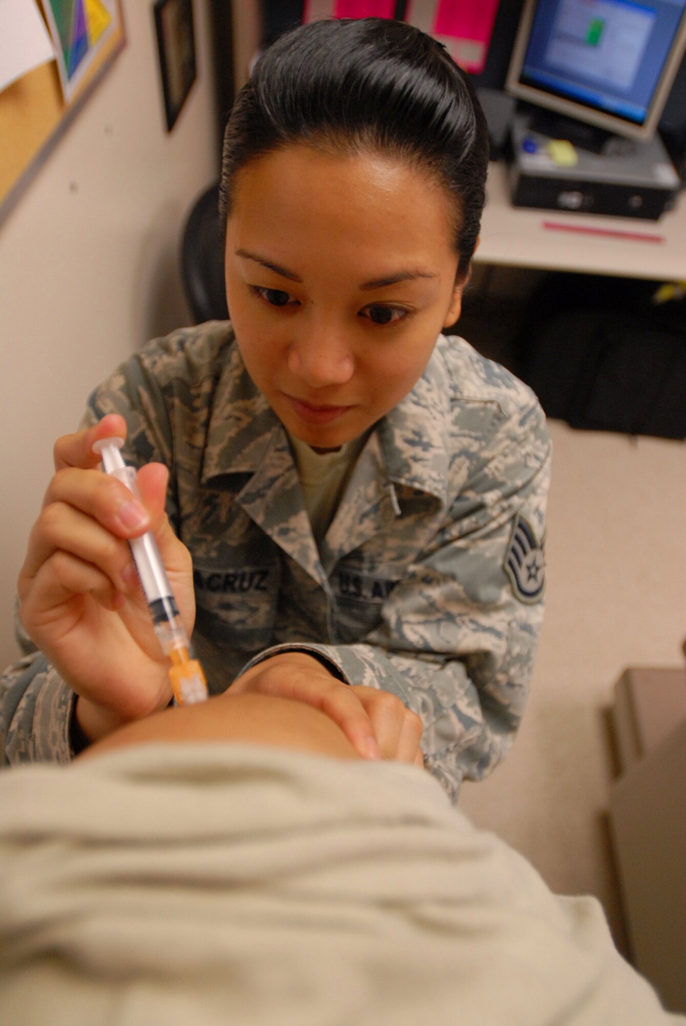 JOINT BASE PEARL HARBOR HICKAM, Hawaii – Staff Sgt. Alria De La Cruz, 15th Medical Group women’s health non-commissioned officer in charge, vaccinates a patient with the H1N1 vaccine. The H1N1 vaccine is a Department of Defense required vaccination for all active duty members and DoD civilians. (U.S. Air Force photo/Senior Airman Gustavo Gonzalez)
