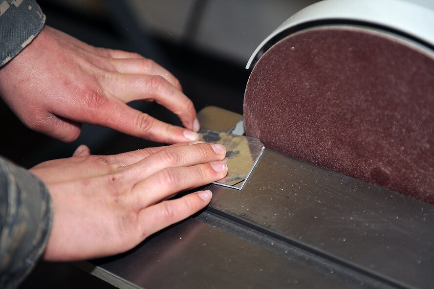 Senior Airman John McKenzie, 4th Equipment Maintenance Squadron aircraft structural maintenance journeyman, fabricates metal on Seymour Johnson Air Force Base, N.C., Feb. 12, 2010. To fabricate sheet metal he uses a sanding machine to trim it down and make the edges smooth. McKenzie is from Roseville, Calif. (U.S. Air Force photo/Senior Airman Ciara Wymbs)   
