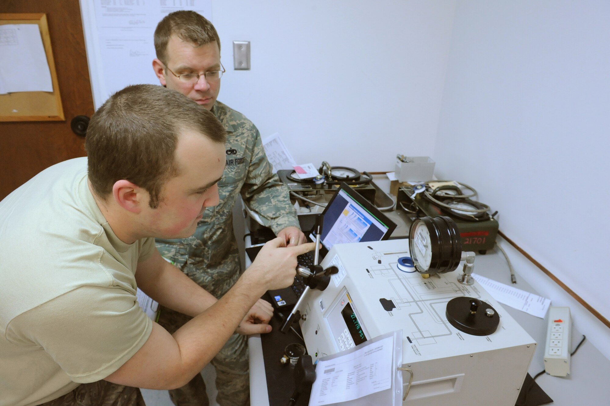 Tech. Sgt. Don Svabek, 4th Component Maintenance Squadron quality program noncommissioned officer in charge, observes Staff Sgt. Jack Lee, 4th CMS test, measurement and diagnostic equipment technician, while calibrating the wing critical pressure gauges on Seymour Johnson Air Force Base, N.C., Feb. 11, 2010. The wing’s critical pressure gauges used at the jet engine shop during pressure set-ups, receive an annual calibration. (U.S. Air Force photo/Senior Airman Whitney Lambert)