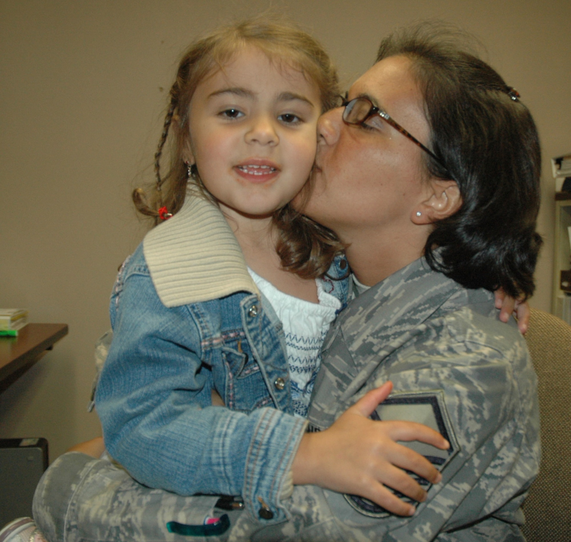 Master Sgt. Kara Stackpole, 439th Aeromedical Staging Squadron, gives a kiss to her daughter, Samantha, after the senior NCO's return from a deployment to Iraq in 2008.  (US Air Force photo/Tech. Sgt. Andrew Biscoe)
