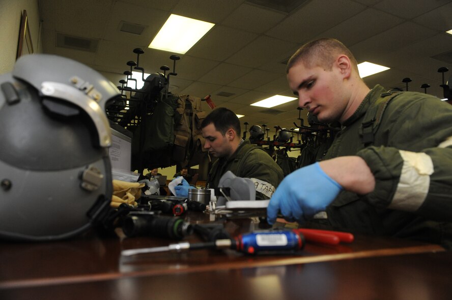 MINOT AIR FORCE BASE, N.D. -- Airman 1st Class Christopher McCain and Airman 1st Class David Melkelsman, 5th Operations Support Squadron aircrew flight equipment apprentices, conduct monthly helmet inspections during Prairie Knight 10-1 here Feb. 11. Prairie Knight is a semi-annual exercise geared to prepare the 5th Bomb Wing Warbirds for a conventional warfare environment and its August 2010 conventional operational readiness inspection. (U.S. Air Force photo by Senior Airman Jesse Lopez)