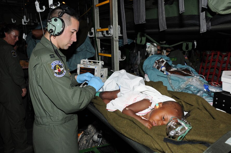 Capt. Doug Stiles, medical crew director with the 43rd Aeromedical Evacuation Squadron from Pope Air Force Base in N.C., cares for an 18-month old female Haitian earthquake victim during a medical evacuation flight onboard a C-130 Hercules on Feb. 2, 2010.  The child suffered a head injury.  (U.S. Air Force photo/Tech. Sgt. Denise Hauser)