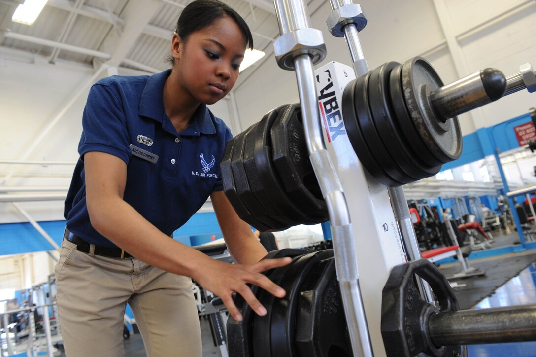ELLSWORTH AIR FORCE BASE S.D.-- Airman 1st Class Elimae Gilchrist, 28th Force Support Squadron fitness specialist, puts away weights at the Bellamy Fitness Center, Feb. 11. The fitness center serves active-duty members, retirees, Department of Defense civilians and their families. (U.S. Air Force photo/Airman 1st Class Corey Hook)