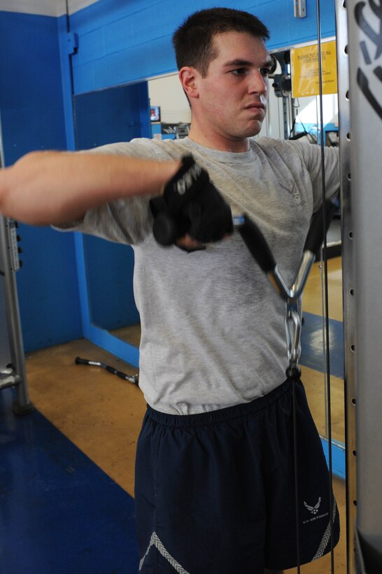 ELLSWORTH AIR FORCE BASE S.D.-- Airman 1st Class Benjamin Craft, Air Force Financial Services Center separation and retirement technician, performs cable upright rows at the Bellamy Fitness Center, Feb. 11. Airman Craft, a native of Pittsburgh, exercises at least four times a week to maintain the fitness lifestyle expected from the new Air Force physical training standards. (U.S. Air Force photo/Airman 1st Class Corey Hook)