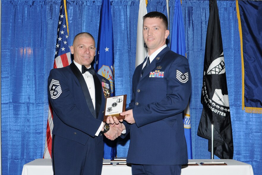 McGHEE TYSON AIR NATIONAL GUARD BASE, Tenn. -- Tech. Sgt. Marcus H. Rains, right, the NCOIC of the Maintenance Operations Center at Beale AFB, Calif., receives the distinguished graduate award for NCO Academy Class 10-3 at The I.G. Brown Air National Guard Training and Education Center here from Chief Master Sgt. James E. Downing, Sr., Feb. 11, 2010.   The distinguished graduate award is presented to students in the top ten percent of the class.  It is based on objective and performance evaluations, demonstrated leadership, and performance as a team player. (U.S. Air Force photo by Master Sgt. Kurt Skoglund/Released)