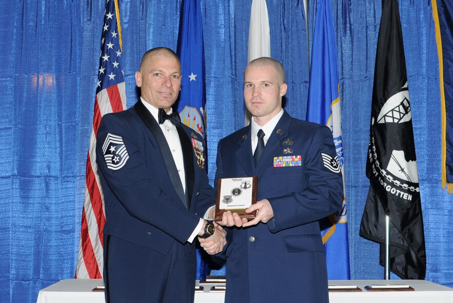 McGHEE TYSON AIR NATIONAL GUARD BASE, Tenn. -- Tech. Sgt. Brian T. Frutiger, right, an imagery analyst with the 13th Intelligence Squadron, Beale AFB, Calif., receives the distinguished graduate award for NCO Academy Class 10-3 at The I.G. Brown Air National Guard Training and Education Center here from Chief Master Sgt. James E. Downing, Sr., Feb. 11, 2010.   The distinguished graduate award is presented to students in the top ten percent of the class.  It is based on objective and performance evaluations, demonstrated leadership, and performance as a team player. (U.S. Air Force photo by Master Sgt. Kurt Skoglund/Released)