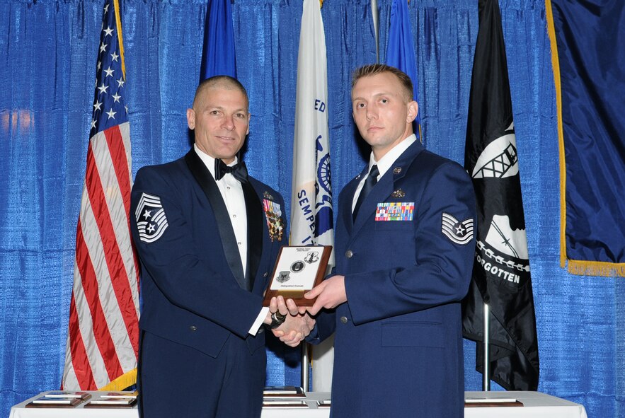 McGHEE TYSON AIR NATIONAL GUARD BASE, Tenn. -- Tech. Sgt. Justin C. Nickel, right, the NCOIC, intelligence systems for the 49th Fighter Wing, Holloman AFB, N.M, receives the distinguished graduate award for NCO Academy Class 10-3 at The I.G. Brown Air National Guard Training and Education Center here from Chief Master Sgt. James E. Downing, Sr., Feb. 11, 2010.   The distinguished graduate award is presented to students in the top ten percent of the class.  It is based on objective and performance evaluations, demonstrated leadership, and performance as a team player. (U.S. Air Force photo by Master Sgt. Kurt Skoglund/Released)