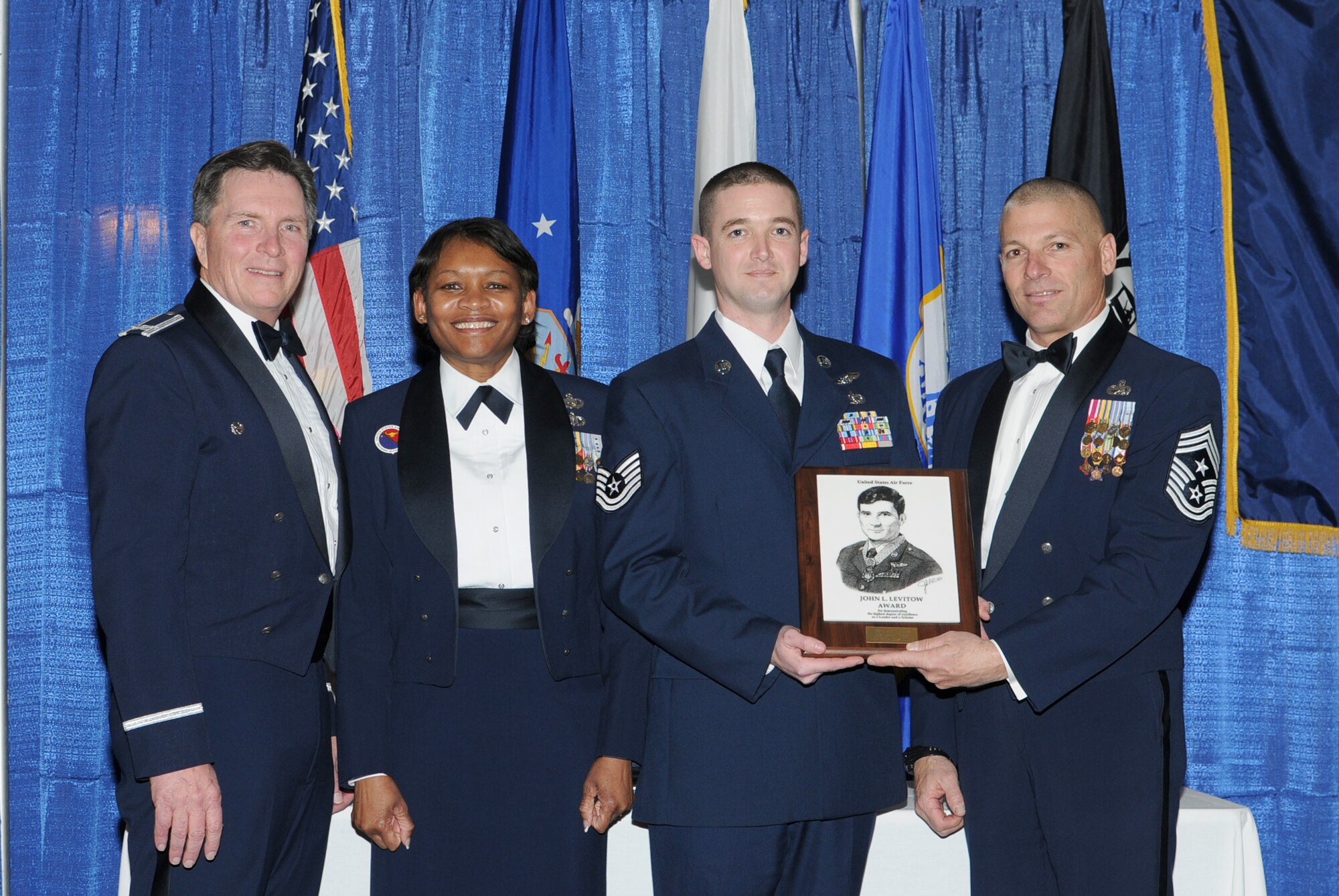 McGHEE TYSON AIR NATIONAL GUARD BASE, Tenn. -- Tech. Sgt. Micah T. Collins, 2nd from right, a loadmaster with the 159th Fighter Wing, Louisiana Air National Guard, receives the John L. Levitow honor award for NCO Academy Class 10-3 at The Air National Guard Training and Education Center here, Feb. 11, 2009.  Also pictured L-R are Col. Richard B. Howard, Chief Master Sgt. Deborah Davidson, and Chief Master Sgt. James E. Downing, Sr. The John L. Levitow award is the highest honor awarded a graduate of any Air Force enlisted professional military education course.  (U.S. Air Force photo by Master Sgt. Kurt Skoglund/Released)