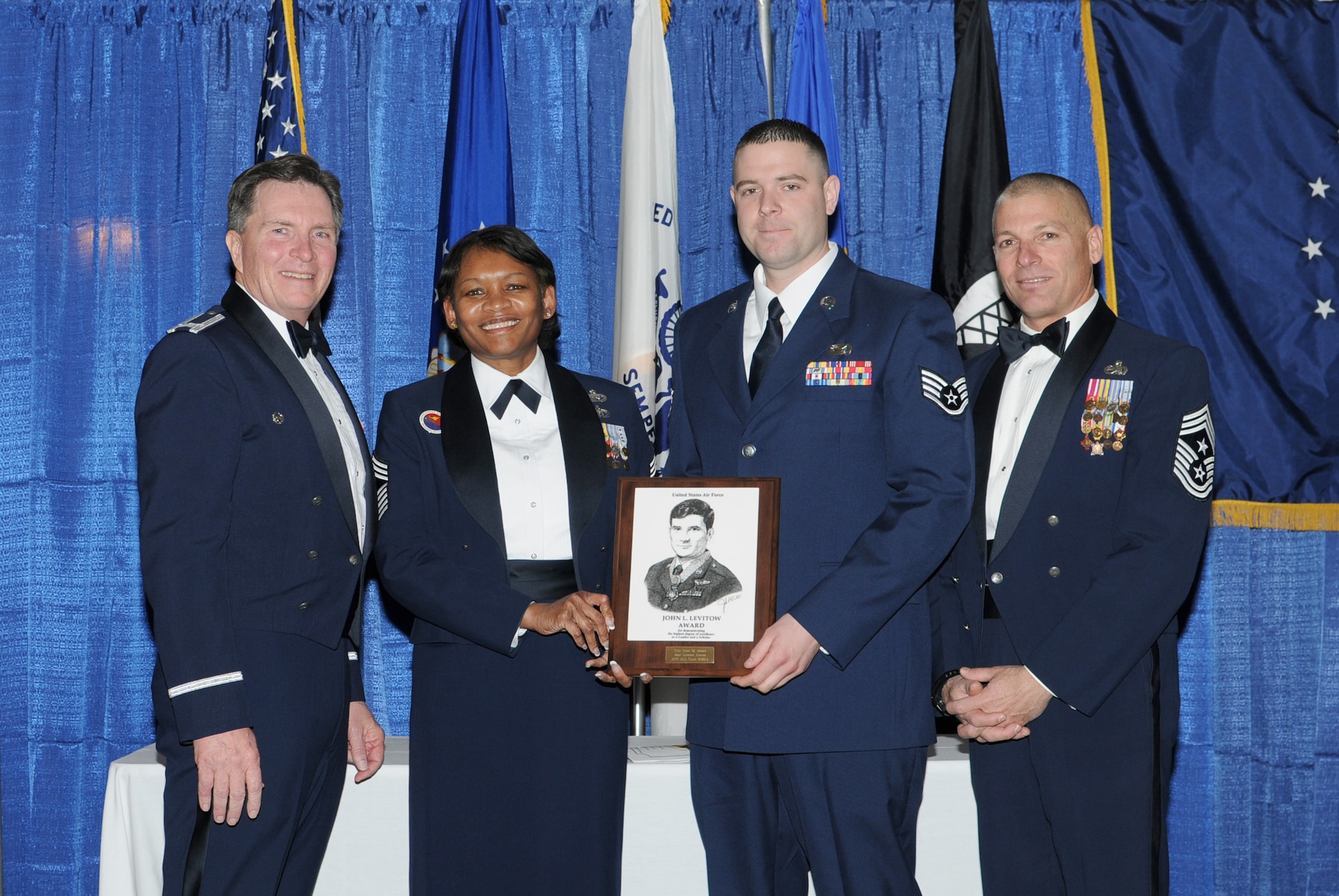 McGHEE TYSON AIR NATIONAL GUARD BASE, Tenn. -- Staff Sgt. Scott M. Moore, 2nd from right, a services craftsman with the 132nd Fighter Wing, Iowa Air National Guard, receives the John L. Levitow honor award for Airman Leadership School Class 10-1 at The Air National Guard Training and Education Center here, Feb. 11, 2010.  Also pictured L-R are Col. Richard B. Howard, Chief Master Sgt. Deborah Davidson, and Chief Master Sgt. James E. Downing, Sr. The John L. Levitow award is the highest honor awarded a graduate of any Air Force enlisted professional military education course.  (U.S. Air Force photo by Master Sgt. Kurt Skoglund/Released)
