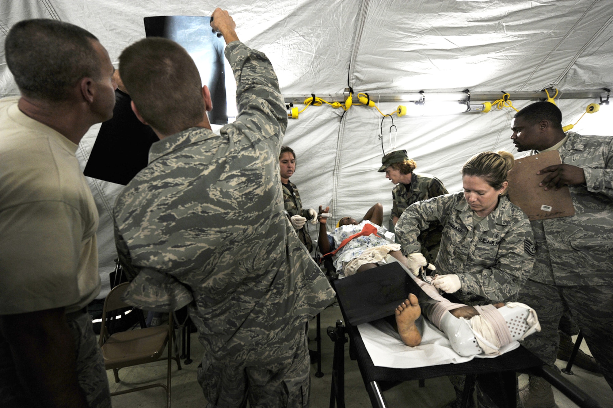 Airmen from Travis Air Force Base, Calif., and Navy corpsman treat earthquake survivors at an expeditionary medical facility Feb. 3, 2010, located along the harbor of Port-au-Prince, Haiti. A 7.0-magnatude earthquake struck Haiti Jan. 12, leaving thousands of Haitians displaced and without access to food, water and vital medical care. (U.S. Navy photo/Petty Officer 2nd Class Todd Frantom)