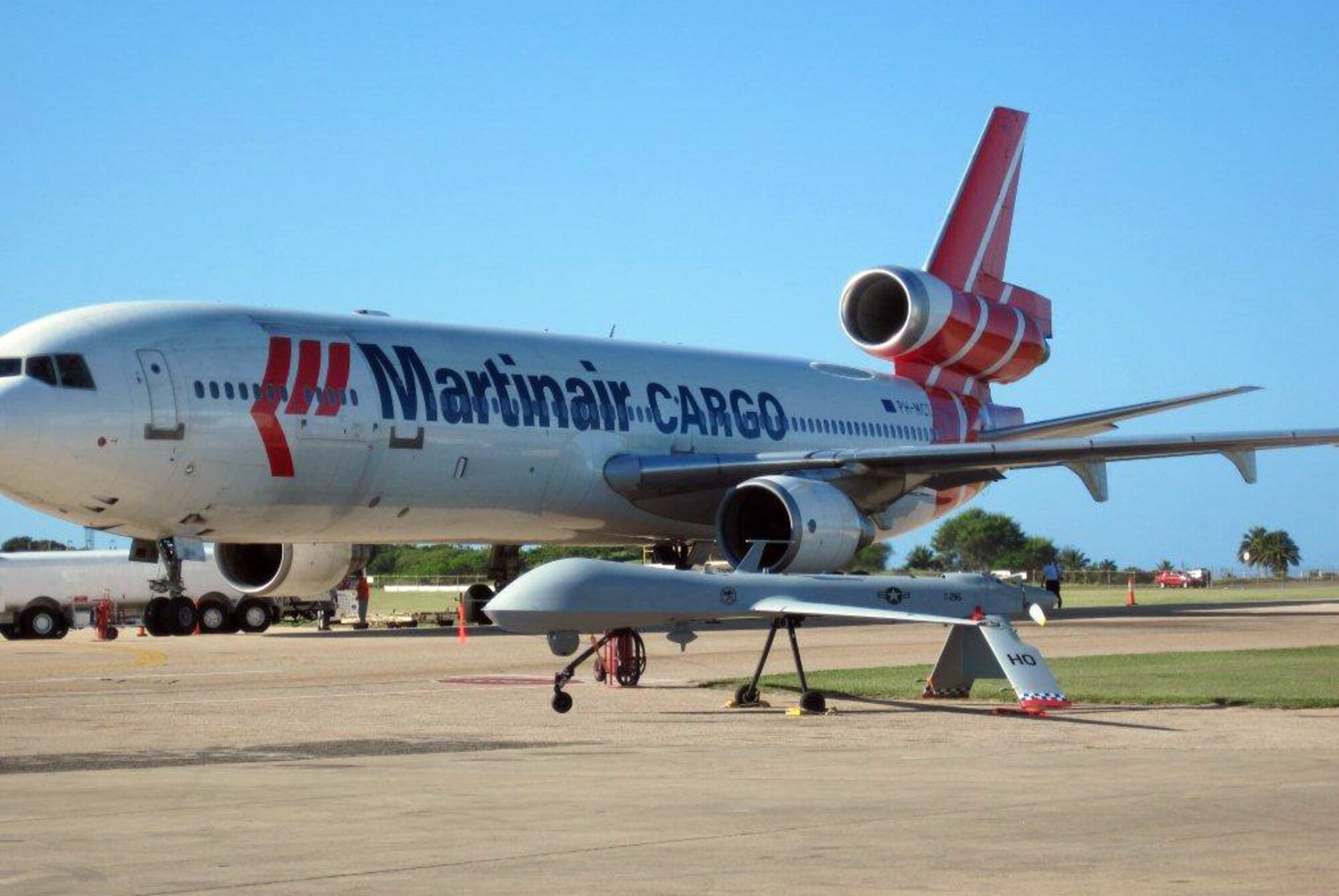 An RQ-1 Predator from Holloman Air Force Base, N.M., sits next to a cargo aircraft on the flight line at a deployed location recently. A team of remotely piloted aircraft personnel from Holloman is currently deployed in support of Operation Unified Response. (Courtesy photo)