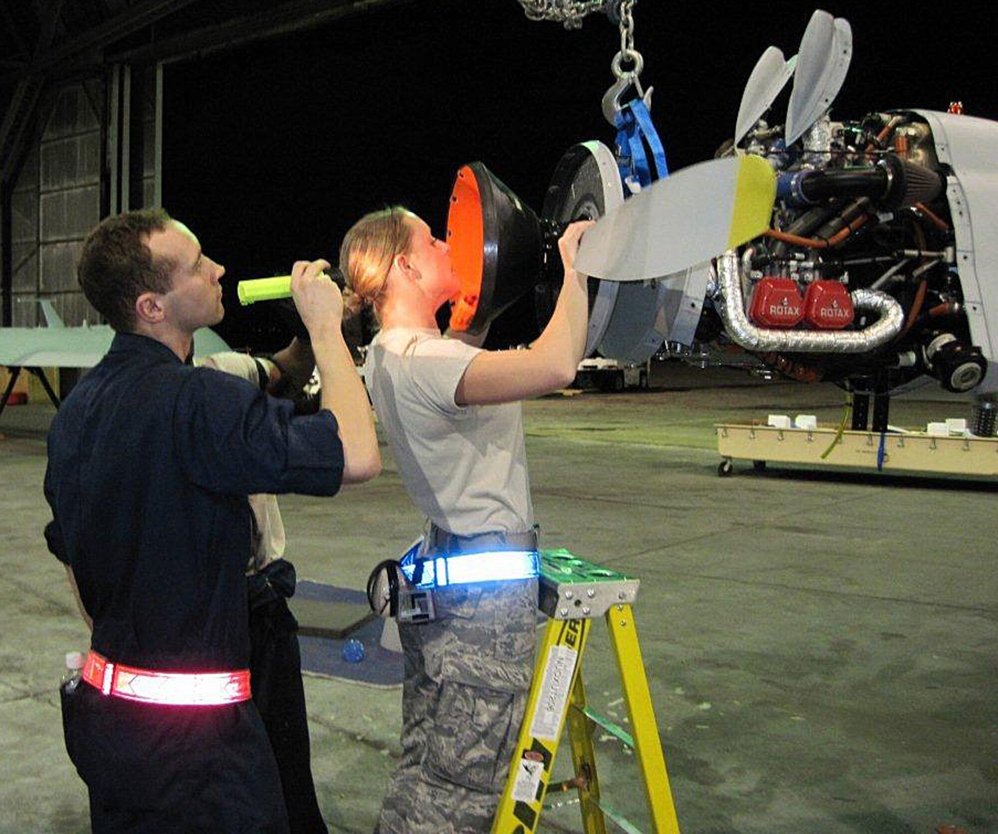 Senior Airman Stephanie Groome, is assisted by another maintainer while she installs a propeller on an RQ-1 Predator during unpack procedures recently. Airman Groome is deployed with a team of 849th AMXS personnel in support of the Operation Unified Response. Airmen Groome is a member of the 849th Aircraft Maintenance Squadron at Holloman Air Force Base, N.M. (Courtesy photo)