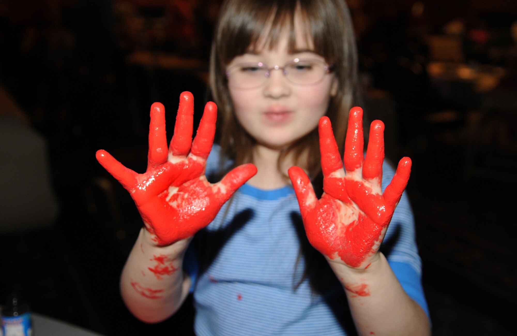 SPANGDAHLEM AIR BASE, Germany – Marie Roberts, daughter of Sandra and Senior Master Sgt. John Roberts, 52nd Maintenance Operations Squadron, shows off her hands after painting a picture during the Children’s Valentine’s Day party at Club Eifel Feb. 10. The club hosted the event, which included food and movies for children and their parents. (U.S. Air Force photo/Senior Airman Nathanael Callon)
