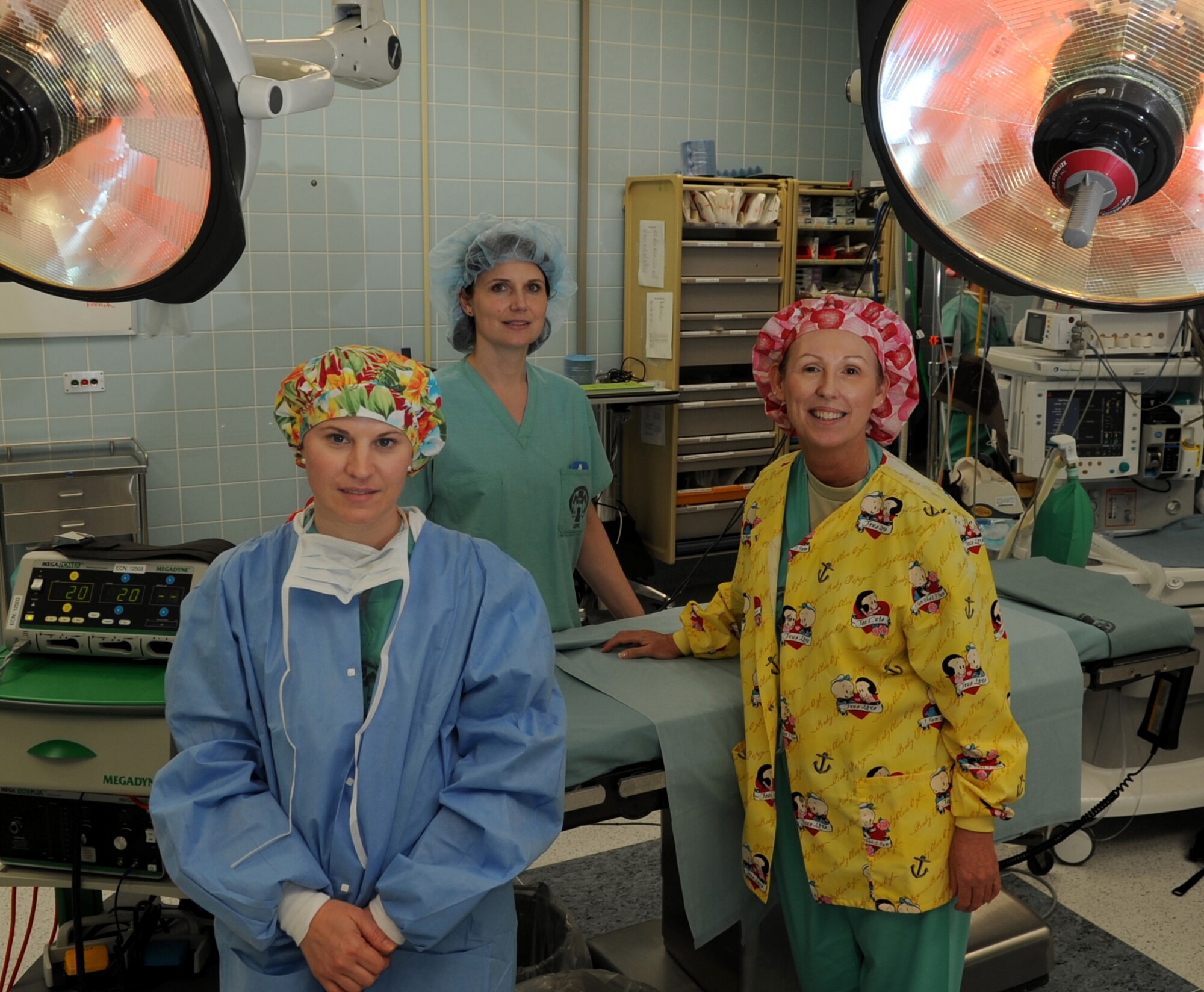 Teresa Sivil, OB/GYN nurse manager and education assistant and training officer, Ludmila Michels, orthopedics nurse manager and education and training officer, and U.S. Air Force Maj. Kenny Harryman, operating room head nurse, pose for a photo in an operating room, Landstuhl Regional Medical Center(LRMC), Germany, Feb. 10, 2010. LRMC is the largest American hospital outside of the United States, serving more than 245,000 U.S. military personnel and their families within the European Command. LRMC is also the evacuation and treatment center for all injured U.S. service members and civilians serving in Afghanistan and Iraq. (U.S. Air Force photo by Airman 1st Class Caleb Pierce)