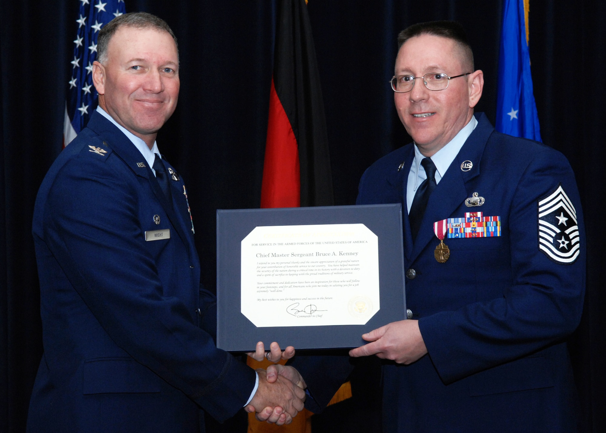 SPANGDAHLEM AIR BASE, Germany -- Retired Chief Master Sgt. Bruce Kenney, right, former 52nd Fighter Wing command chief, receives a presidential letter of appreciation from Col. Tip Wight, 52nd FW commander, during Chief Kenney's retirement ceremony Feb. 11 at Club Eifel. Chief Kenney served in the Air Force for 30 years. (U.S. Air Force photo/Airman 1st Class Nick Wilson)