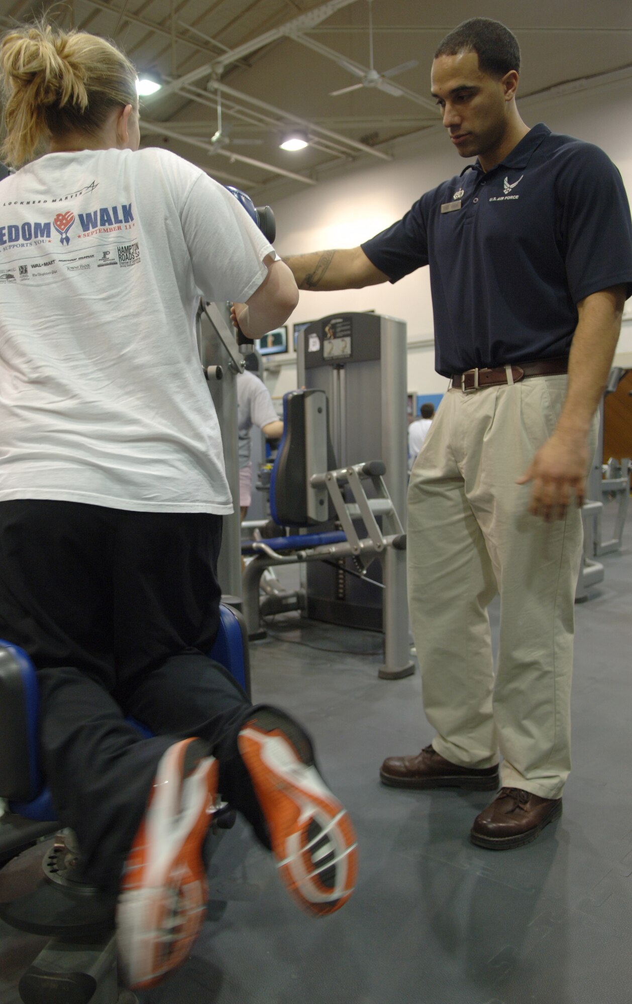 Naomi Voss (left), Air Force spouse, completes sets on the torso rotation machine during a work-out session at the Northside Fitness Center as her personal trainer, Staff Sgt. Ryan Voisin, 86th Services Squadron fitness specialist, looks on, Ramstein Air Base, Germany, Feb. 10, 2010. Mrs. Voss is competing in the fourth-annual Biggest Loser Competition. (U.S. Air Force photo by Senior Airman Amanda Dick)